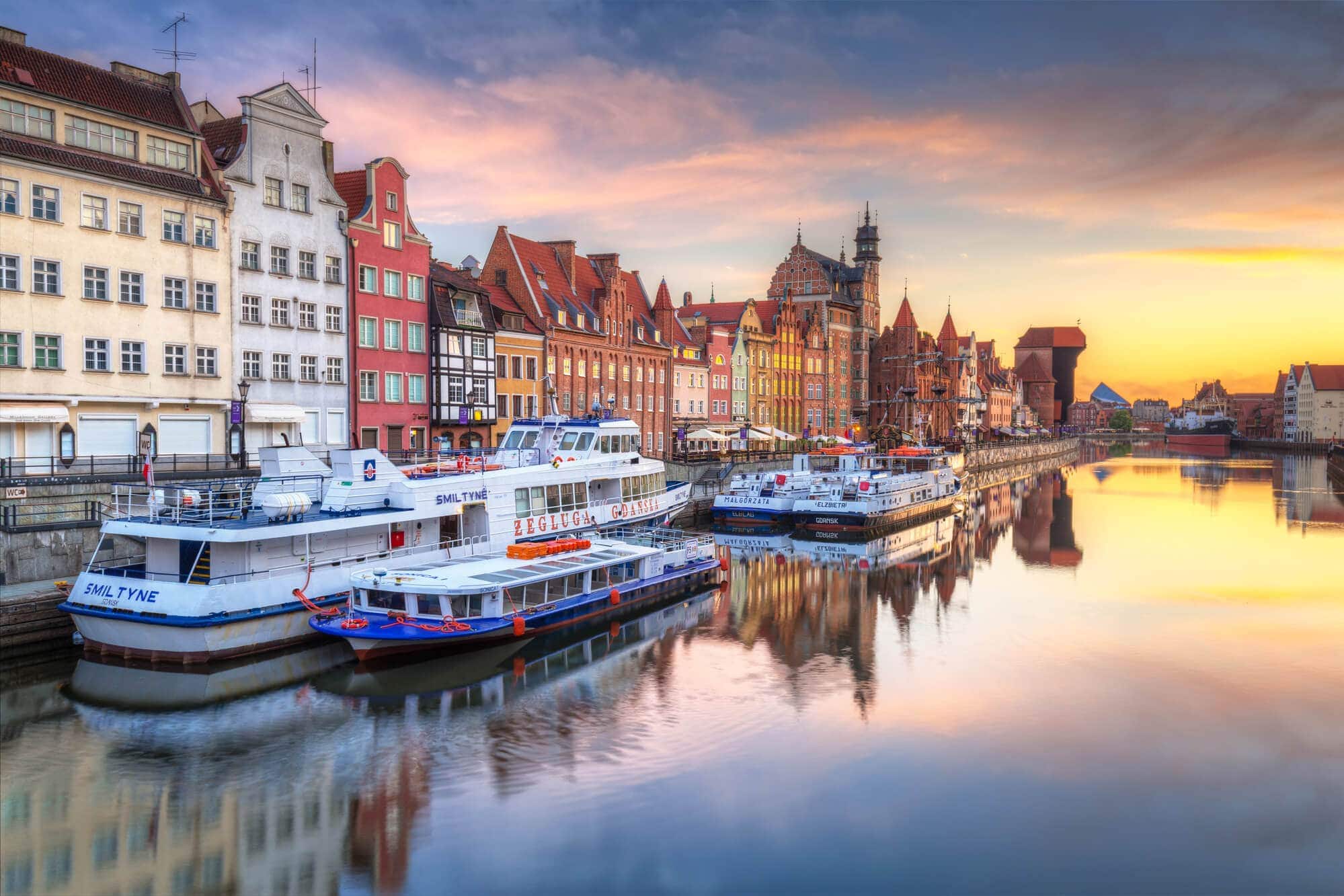 Gdansk river, with boats and colorful buildings at sunset. A must in any 2 day Gdansk itinerary