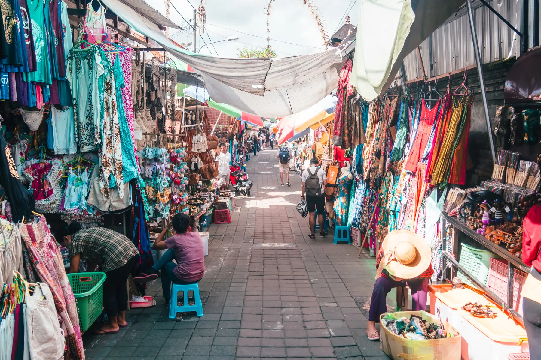 Almost empty street at Ubud Art Market early in the morning, with stalls selling souvenirs at both sides.