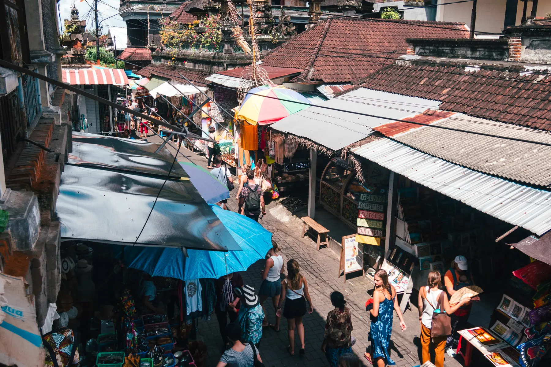 Looking down on people walking down one of the alleys lined by stalls at Ubud Art Market.