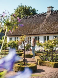 Girl walking in the manicured garden outside the old Queen's Tearoom in Gentofte outside Copenhagen, one of my favorites on this Denmark Bucket List.