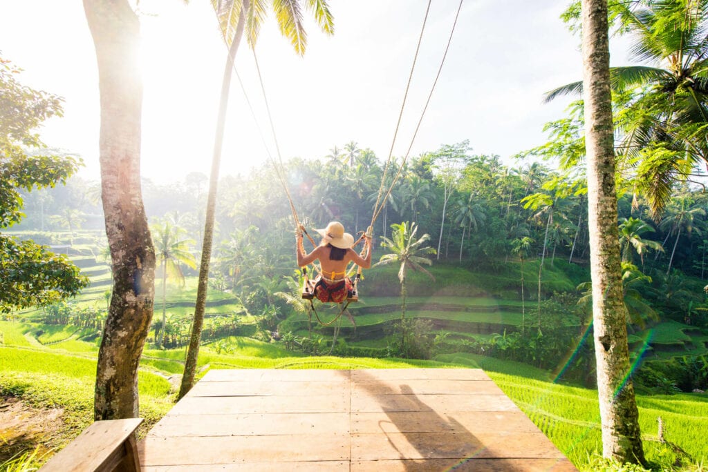 A girl at the popular Tegalalang Rice Terrace swing in Ubud at sunrise