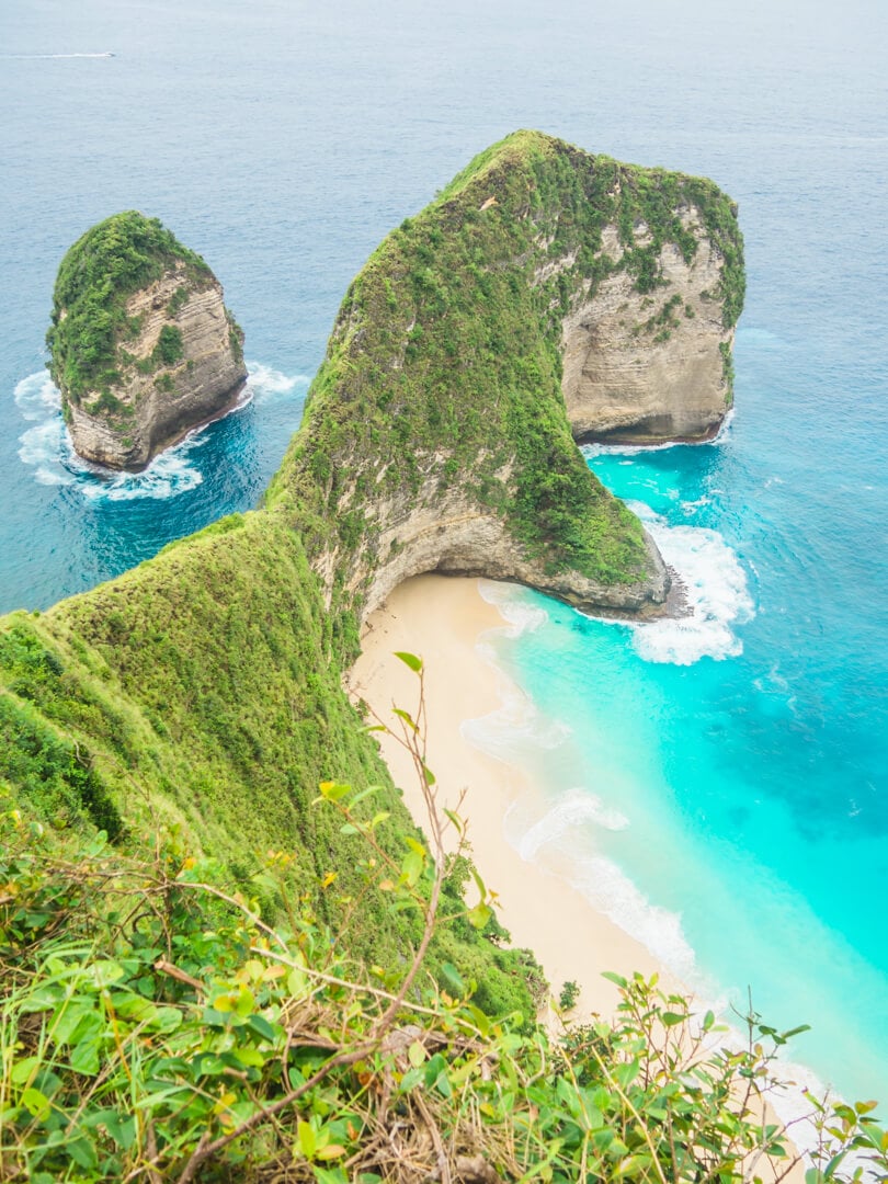 View from the top of Kelingking Beach on Nusa Penida, turquoise water and a green cliff looking like the head of a T-Rex. A must during your two weeks in Bali.