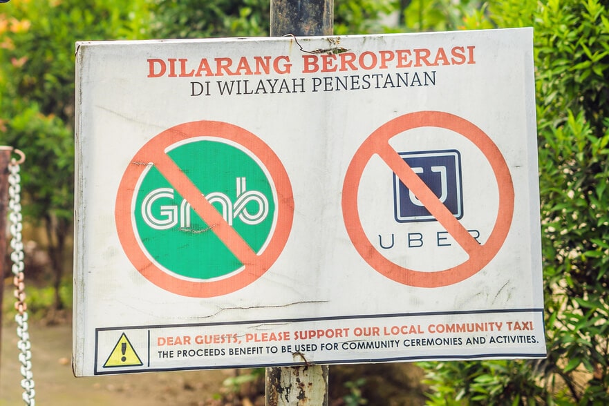 Sign in Bali with Grab and Uber logos crossed out by the local taxi mafia in Uluwatu Bali.