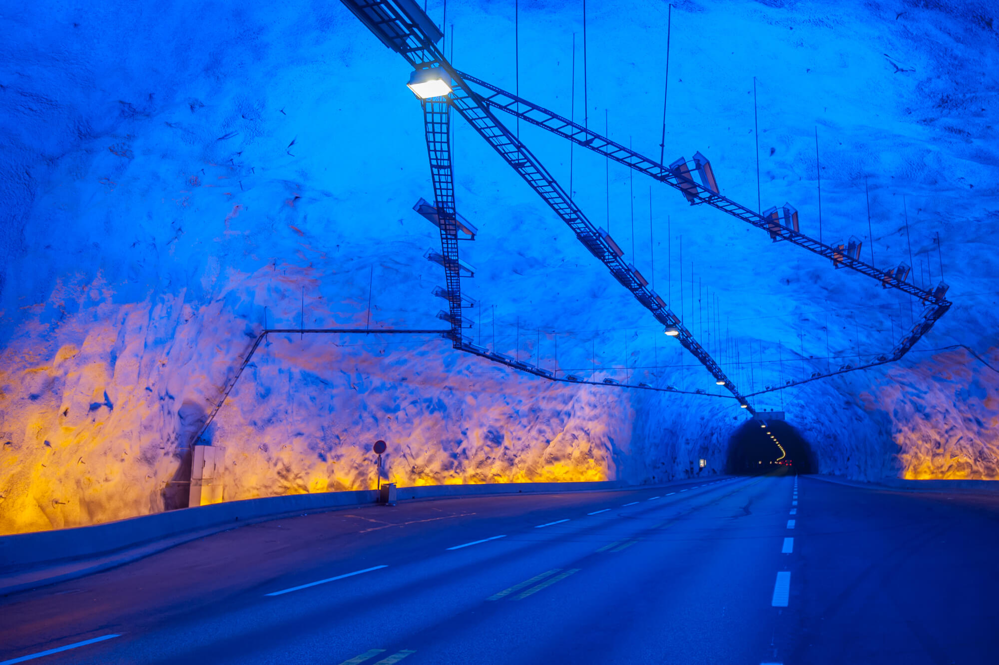 Driving through a cave with yellow and blue lights in Lærdalstunnelen in western Norway