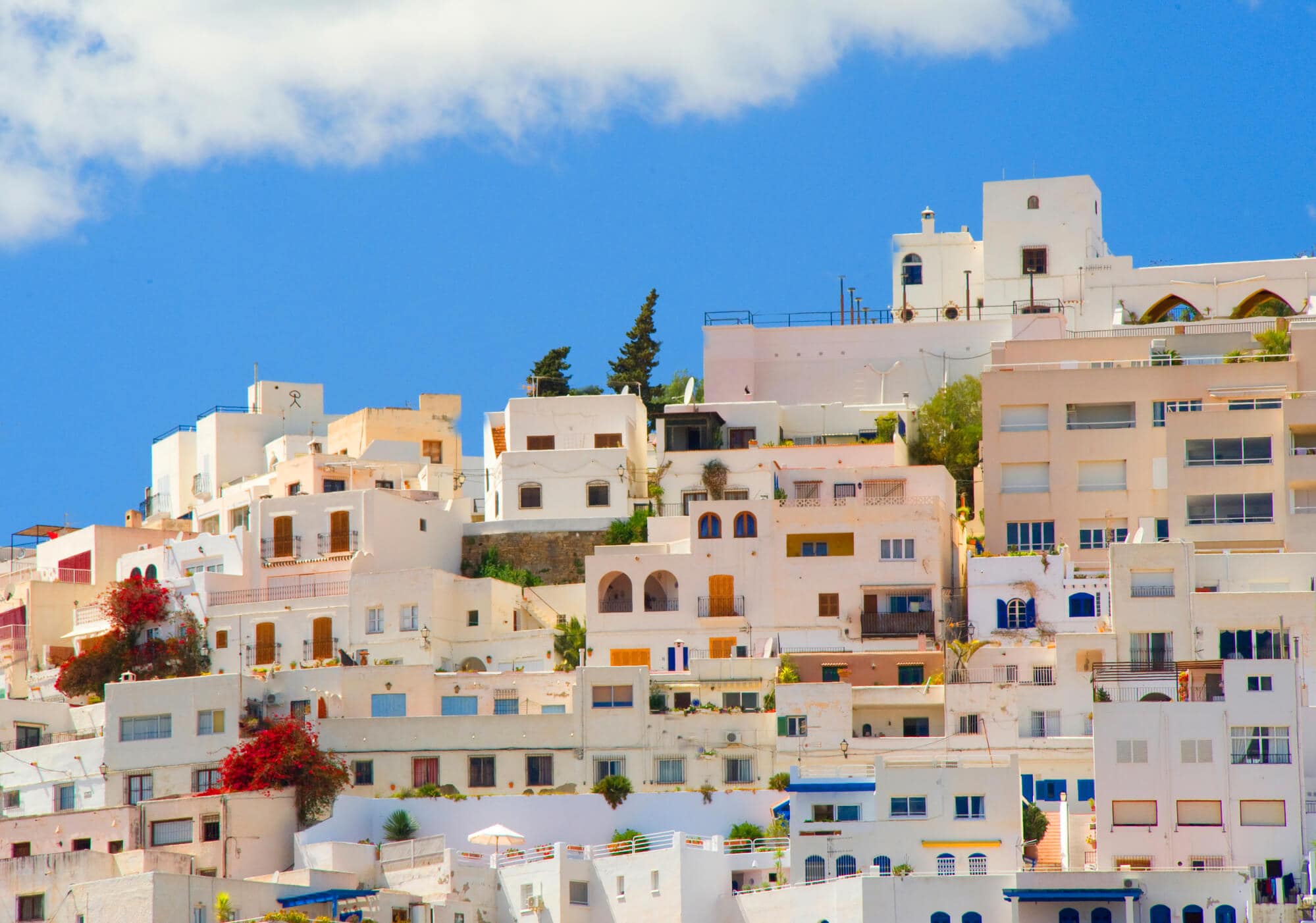 White houses with different colored doors on top of a hill in Mojácar Pueblo in Andalucía, Spain