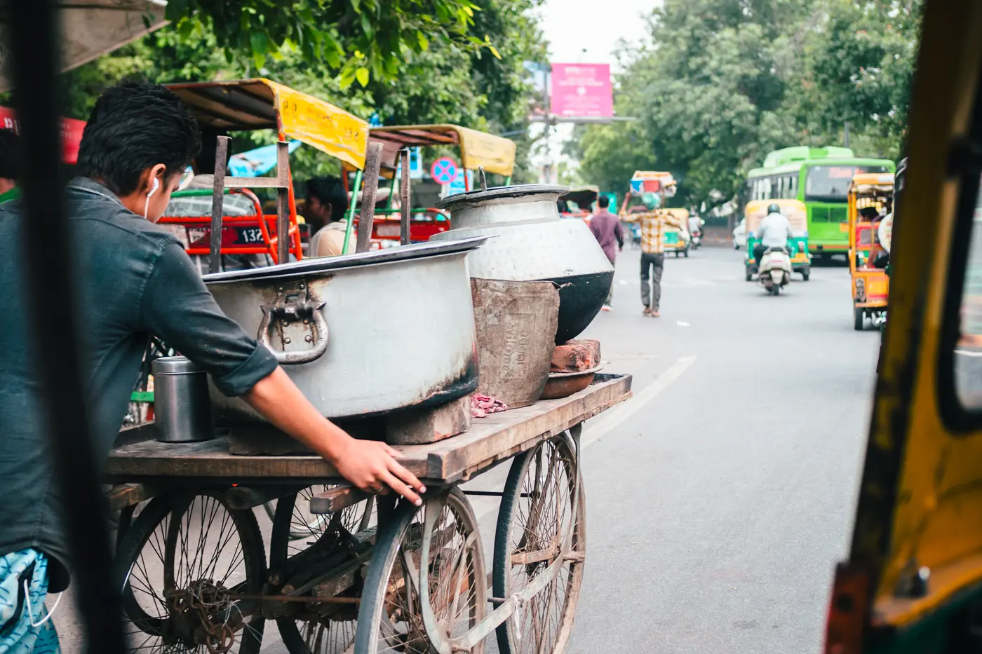 Man pushing a street food cart on the busy streets on Delhi, shot from a tuk-tuk during 2 days in Delhi.