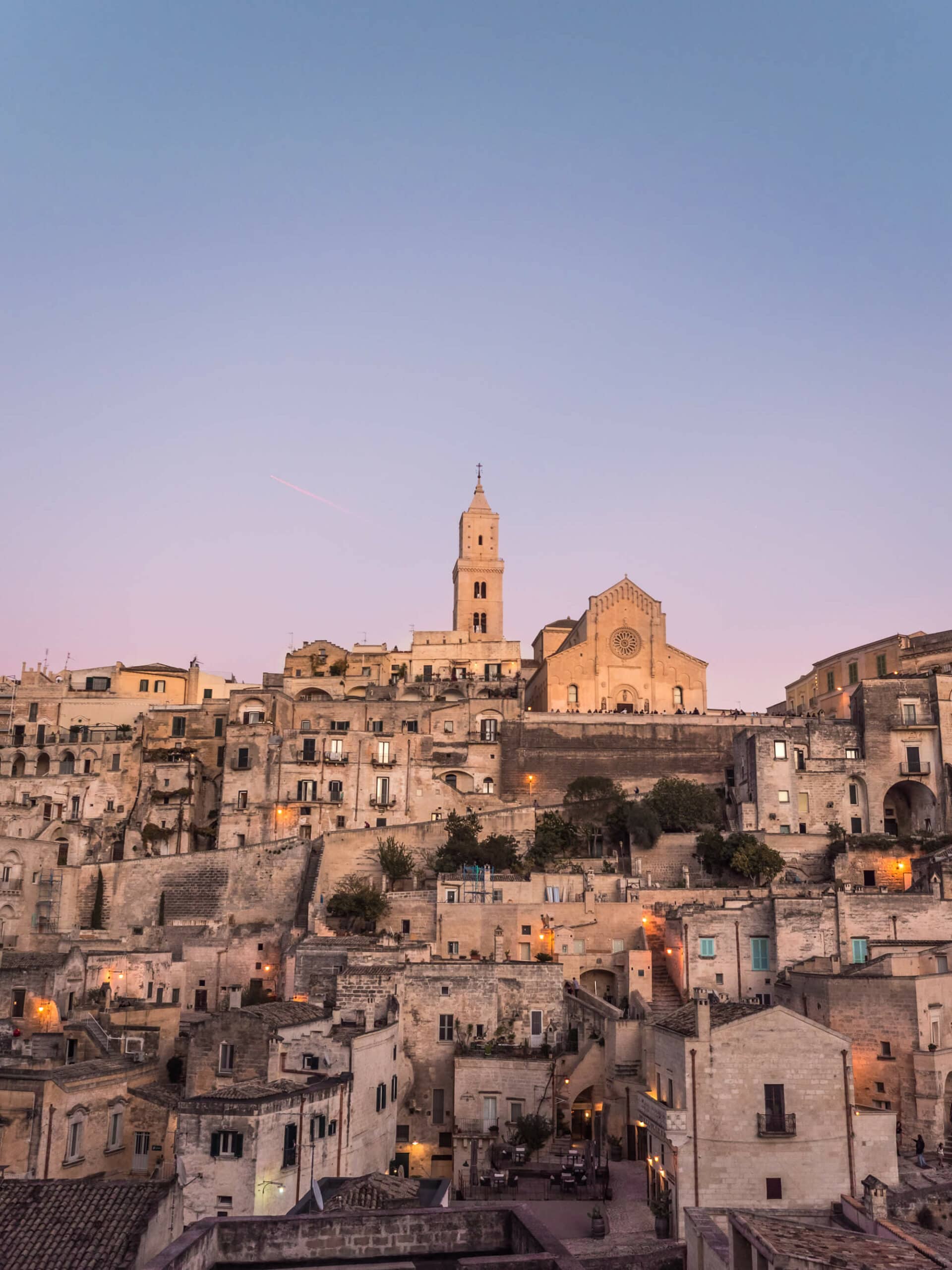 The stone town of Sassi Di Matera set against a purple sky at sunset - The best hotel view in Matera