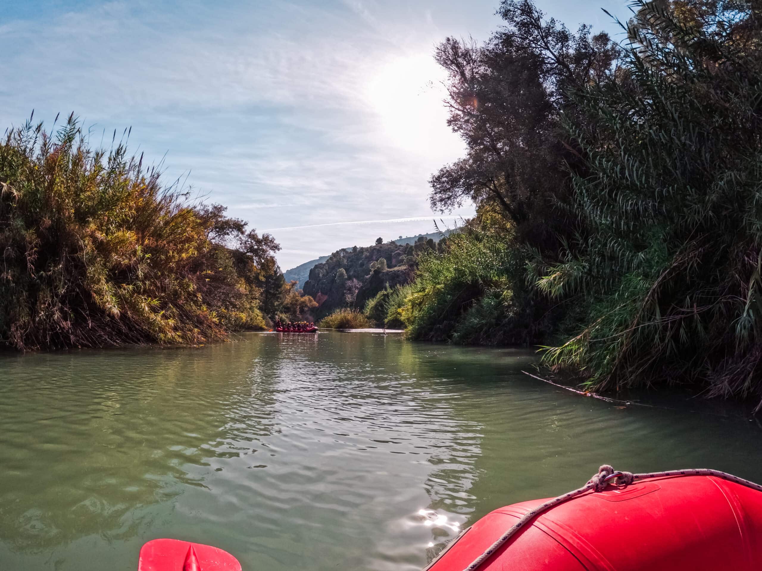 Rafting the Segura River in Murcia Spain. Sitting in a red rubber boat floating down a calm, green river. 