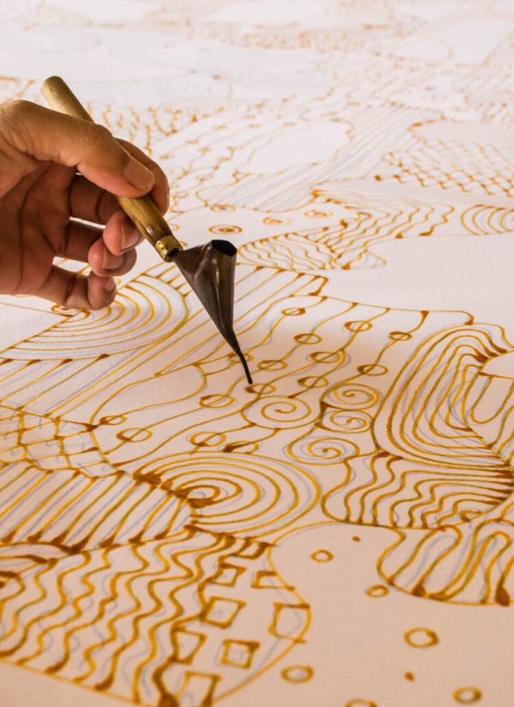 close up of two hands creating a beautiful batik patern, one of the most unusual things to do in Bali.