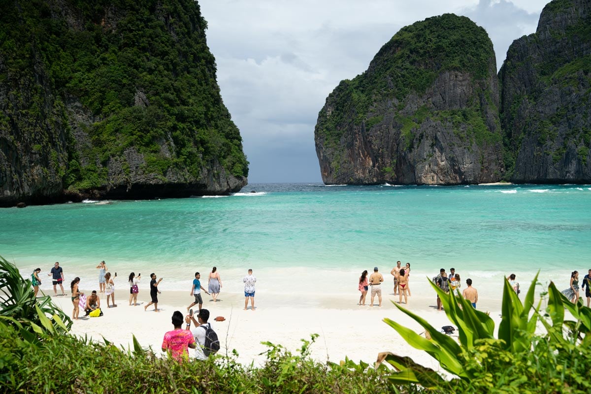View of the white beach in Maya Bay (Phi Phi Islands) lined by greenery and towering cliffs with, during one of the best tours in Krabi.