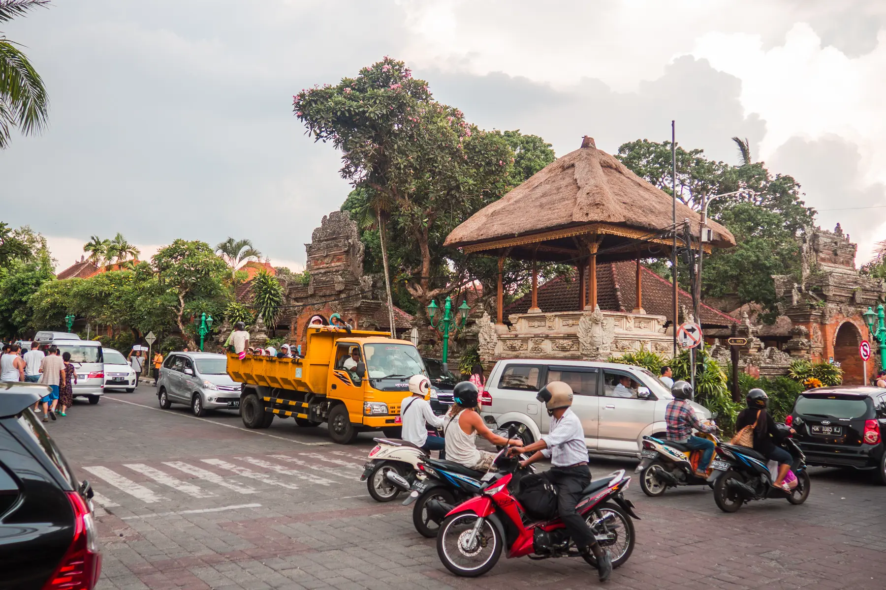 Intersection in Ubud Bali with scooters, trucks and cars on a cloudy day, things to know before going to Bali.