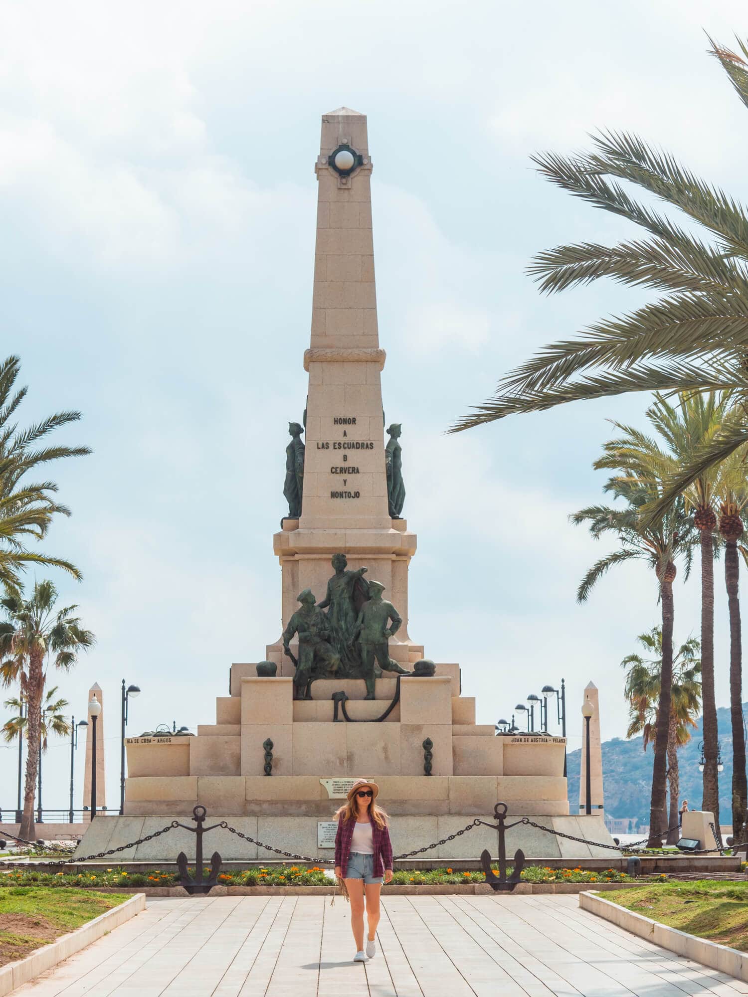 Girl walking in front of a tall monument close to Cartagena Spain Cruise Port.