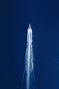 Drone look on a fast boat from Bali to Lombok on dark blue water