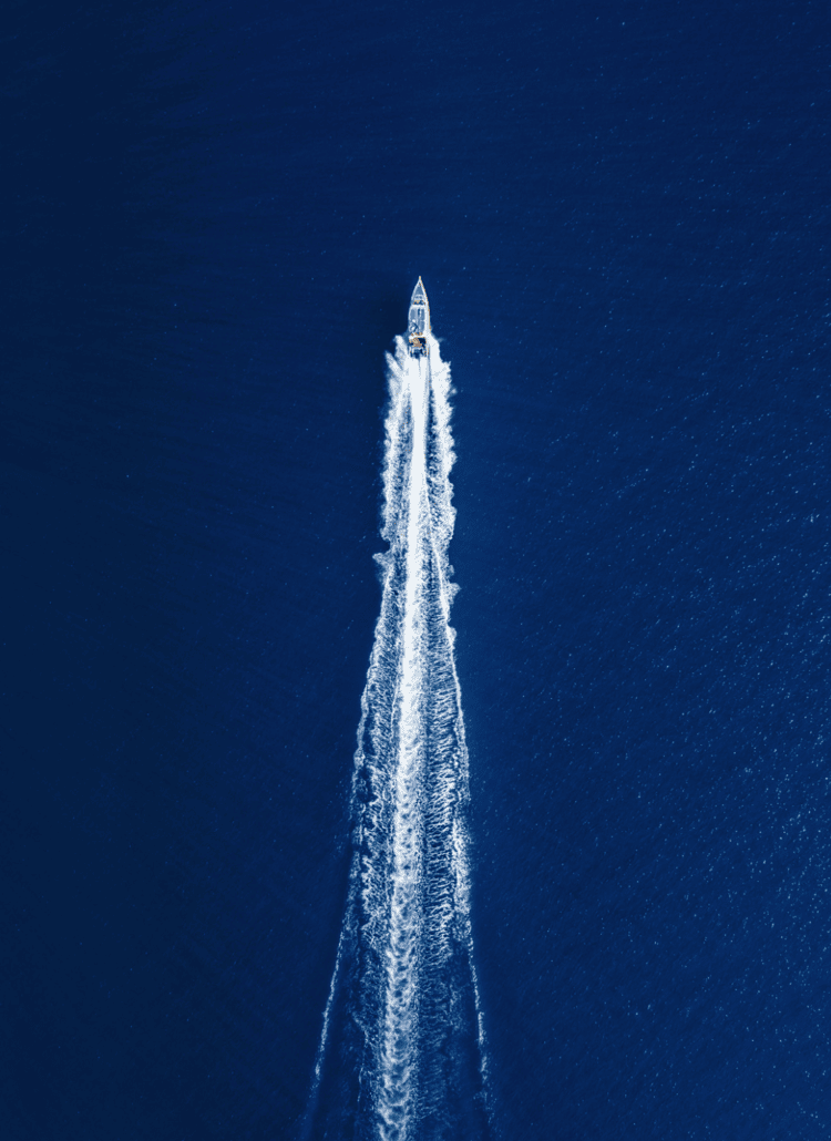 Drone look on a fast boat from Bali to Lombok on dark blue water