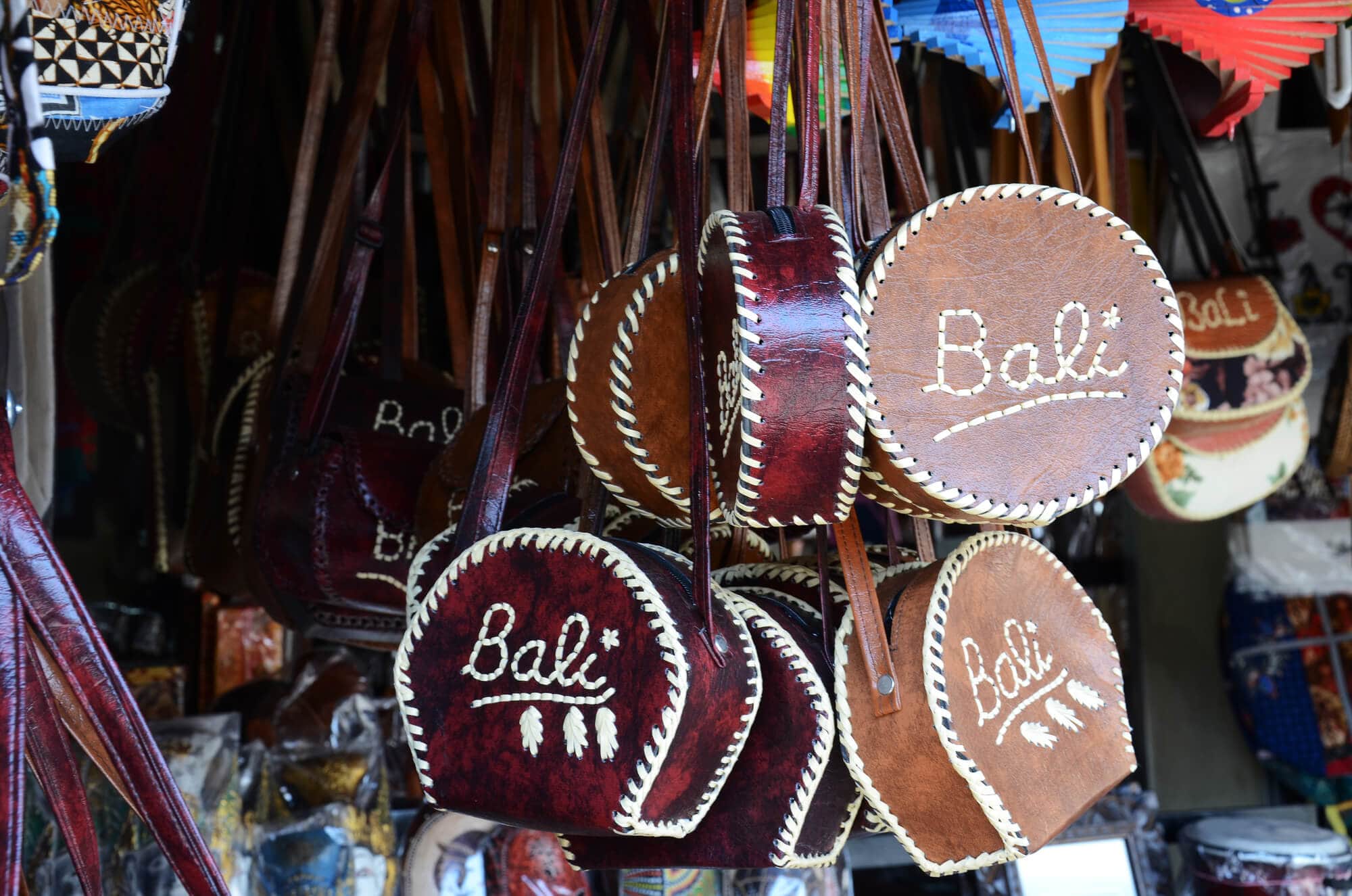 Leather bags hanging from the ceiling at a market in Canggu