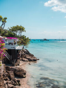 View of The Deck Restaurant covered in pink Bougainvillea along the Boardwalk in Jungut Batu on a day trio to Nusa Lembongan.