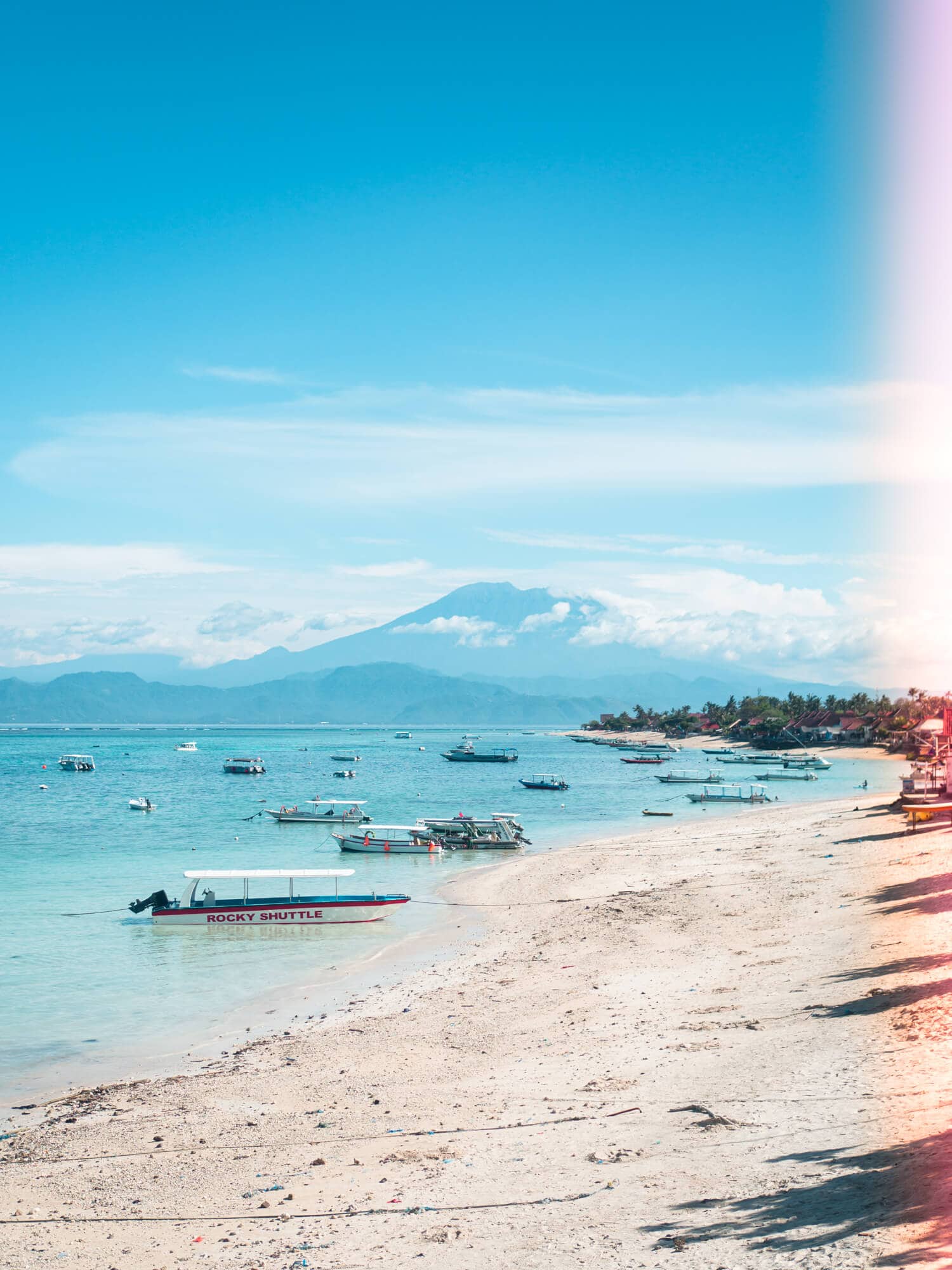 View of Bali's Mount Agung in the distance on a clear day from Jungut Batu Beach with boats in the foreground, during a day trip to Nusa Lembongan.