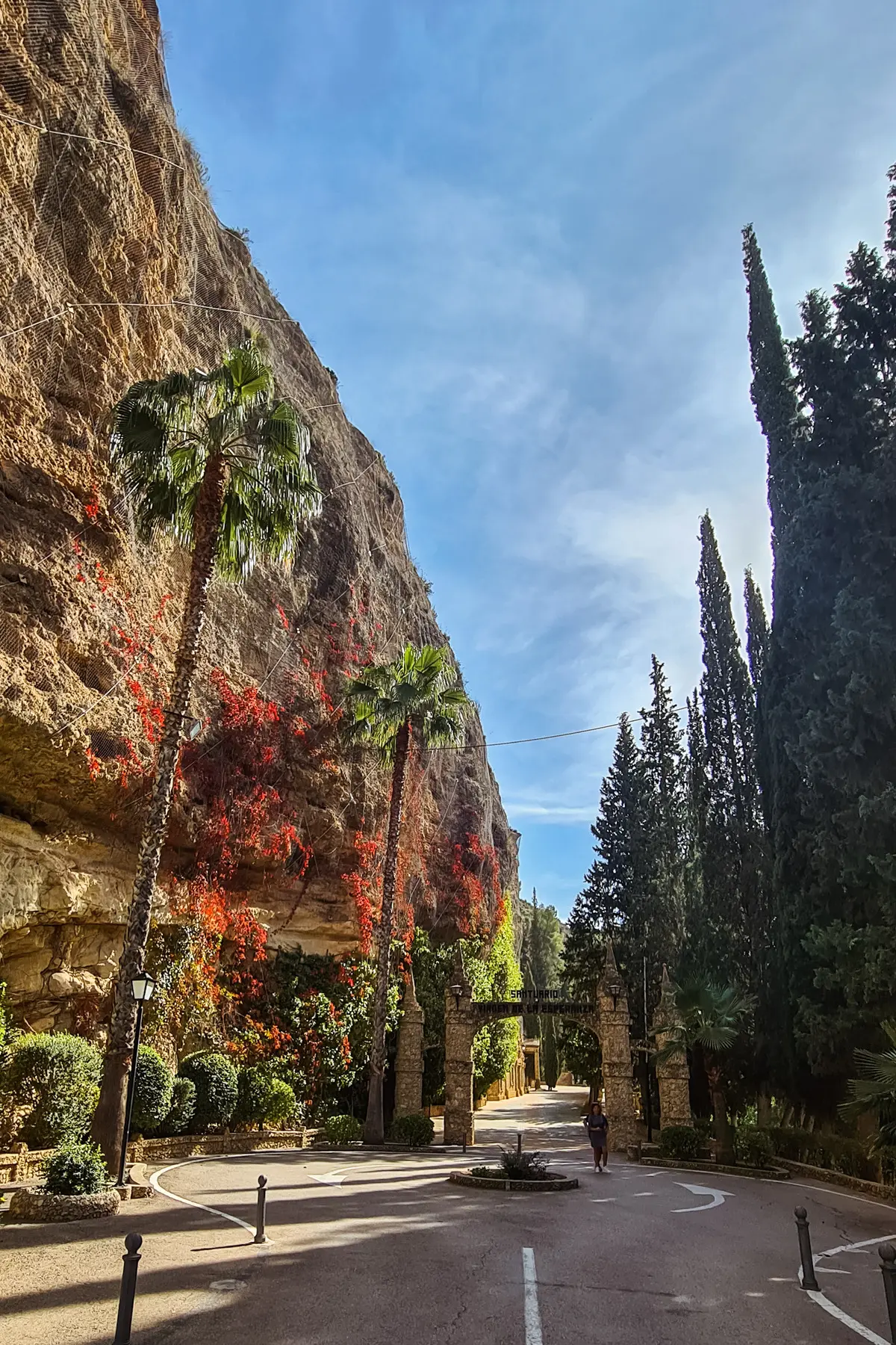 Two tall palm trees against a limestone cliff at the entrance of Our Lady of Hope Sanctuary, one of the best things to do in Murcia.