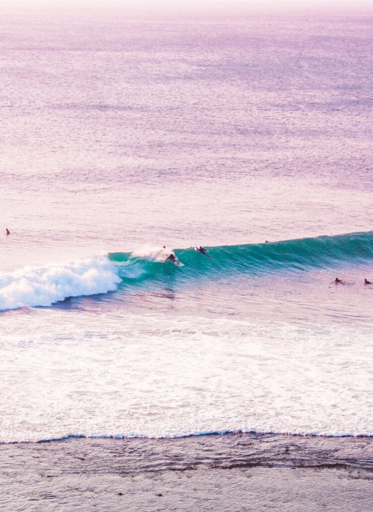 Surfer on a wave at Uluwatu early in the morning, the perfect place for a surf and yoga retreat in Bali.