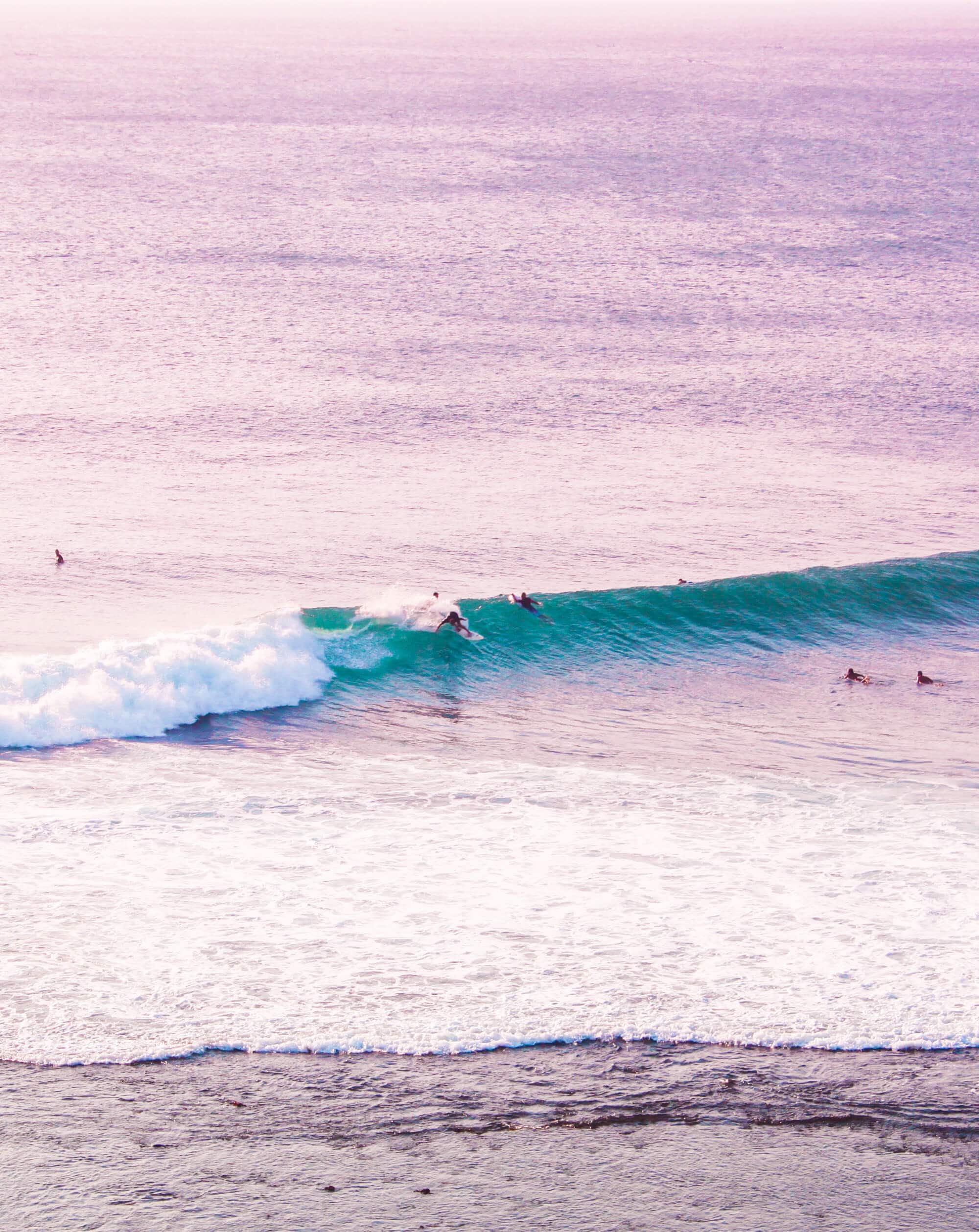 Surfer on a wave at Uluwatu early in the morning, the perfect place for a surf and yoga retreat in Bali.
