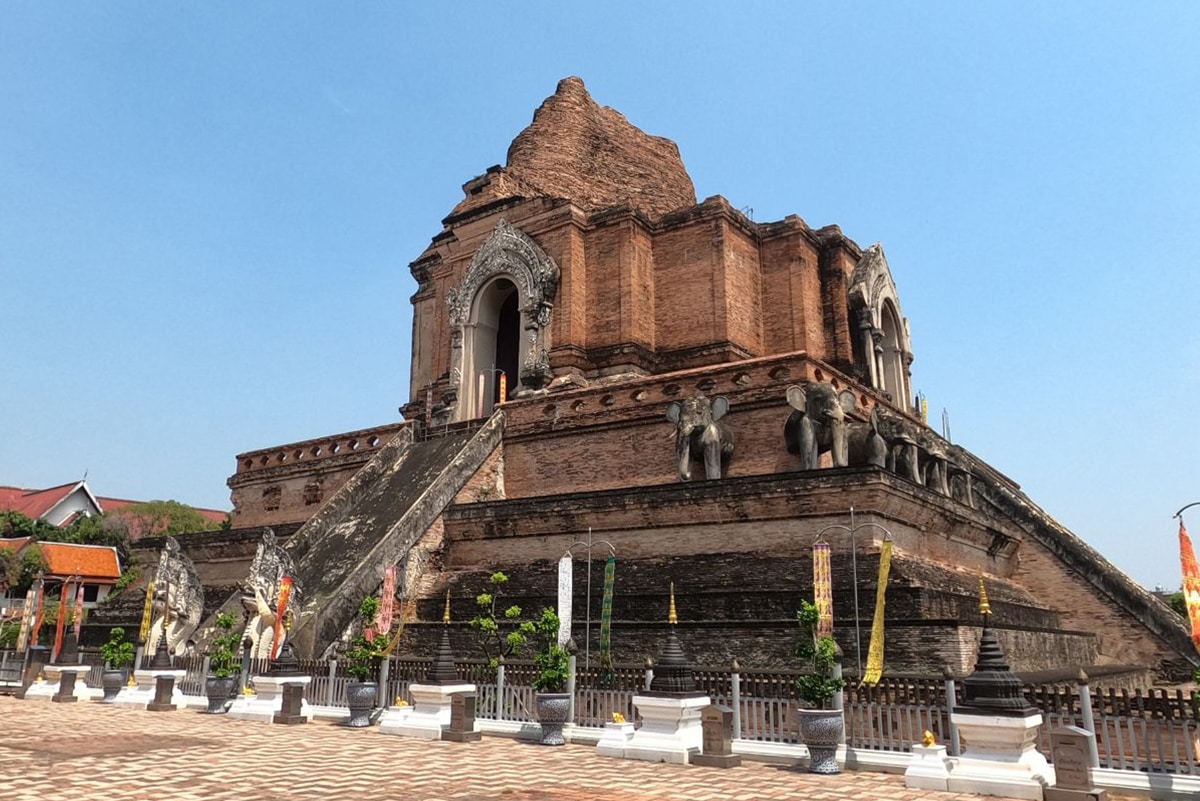 The large brick temple Wat Chedi Luang in Chiang Mai set against a clear blue sky.