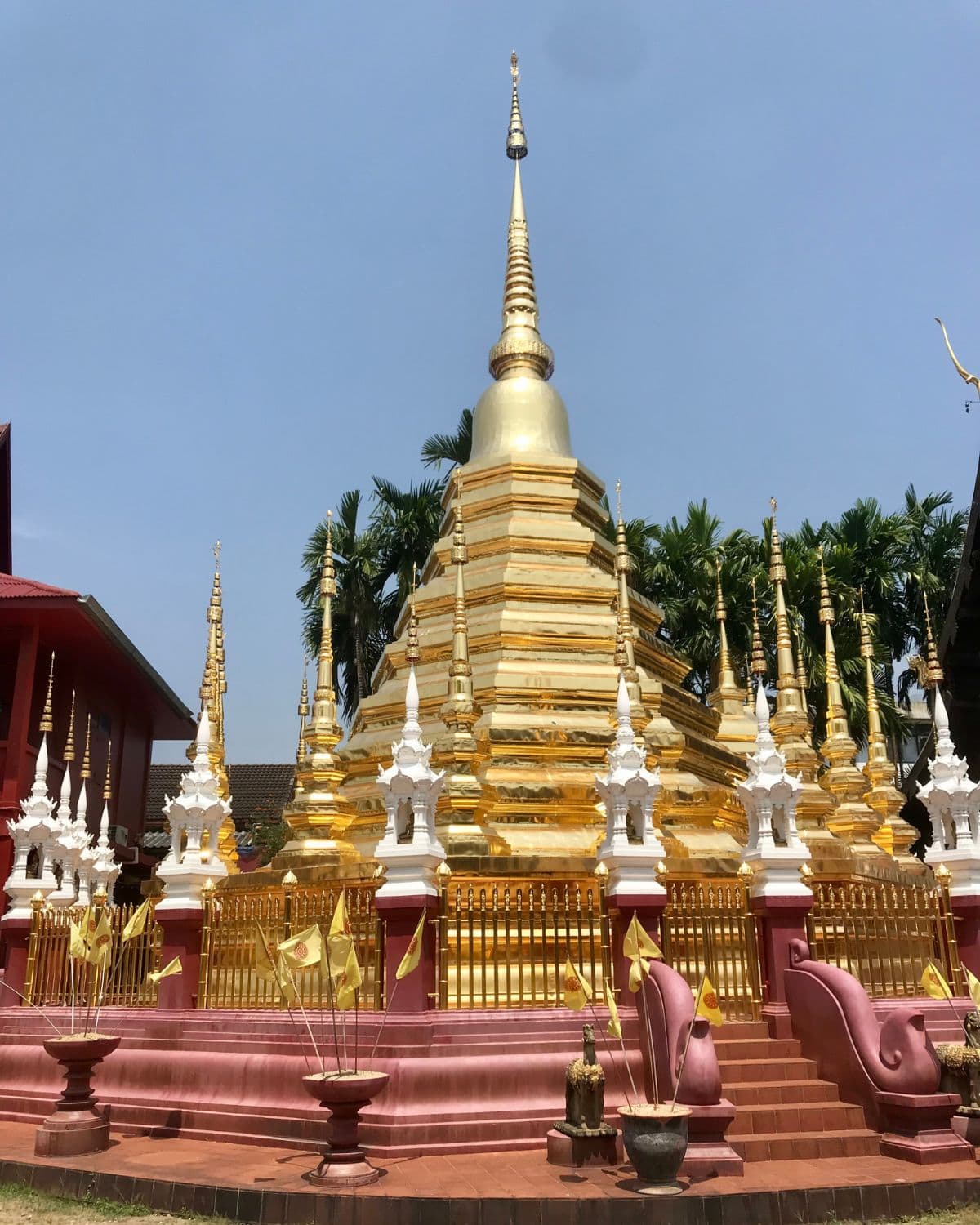 Large golden chedi surrounded by white shrines inside Wat Phan Tao, one of the best temples in Chiang Mai, Thailand.