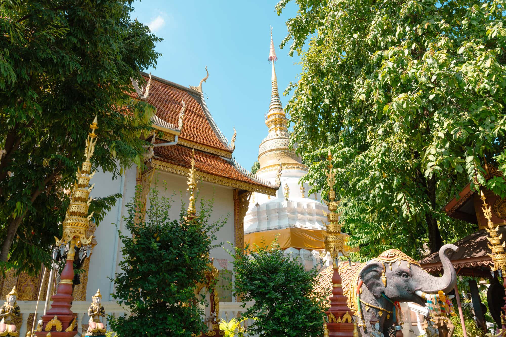Elephant statue in front of the white Wat Lam Chang and chedi in Chiang Mai, Thailand.