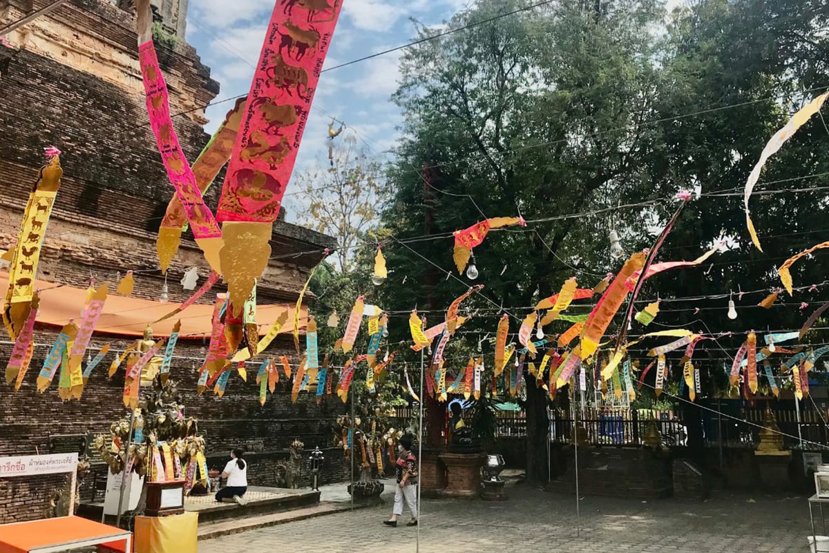 Prayer flags in red, yellow and orange colors at Wat Lok Moli temple in Chiang Mai, Thailand.