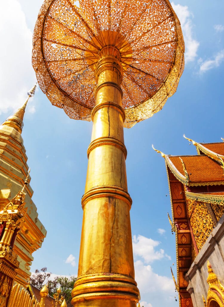 Gold chedi, temple and decoration seen from below on a sunny day at Wat Phra That Doi Suthep, one of the most impressive temples in Chiang Mai.