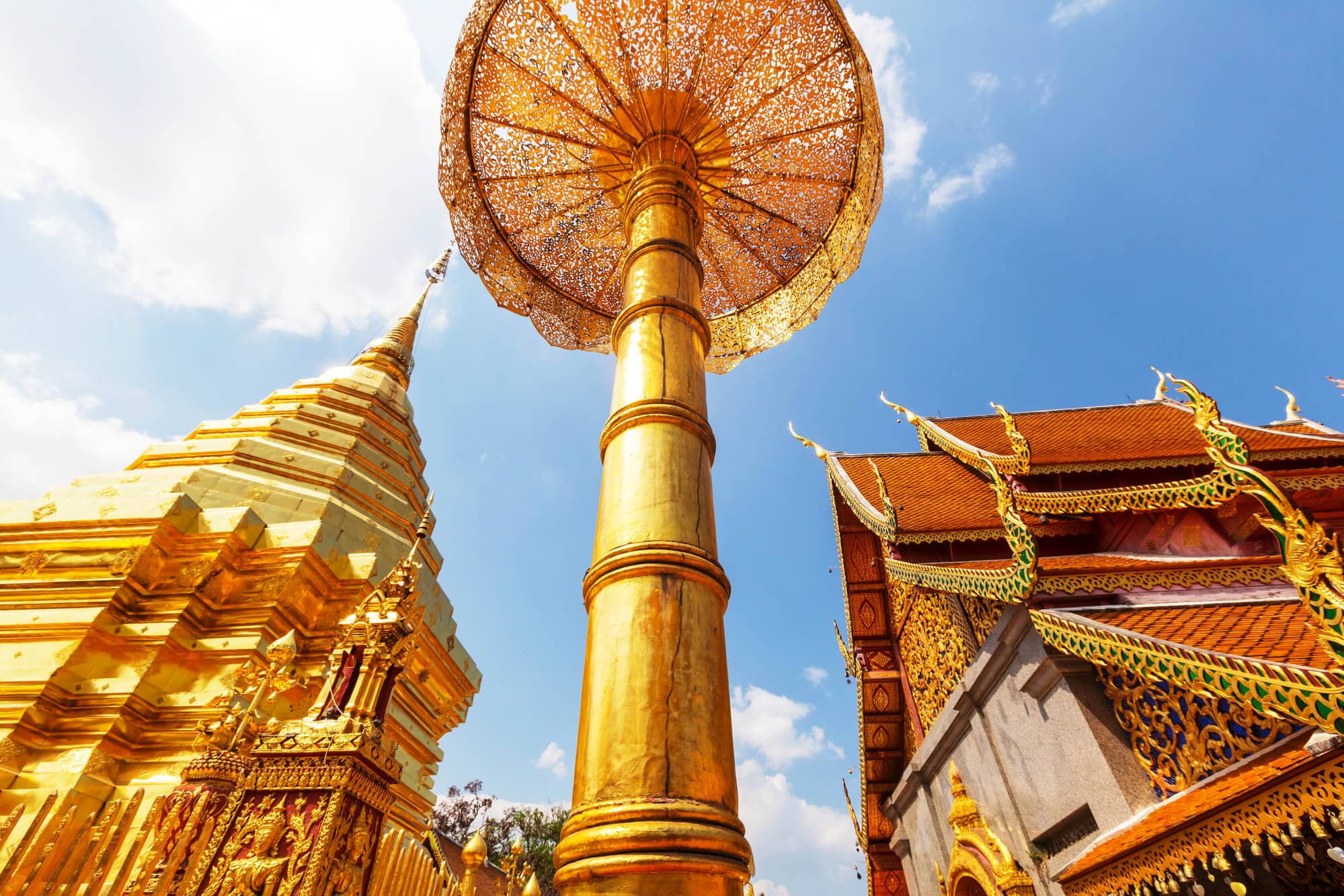 Gold chedi, temple and decoration seen from below on a sunny day at Wat Phra That Doi Suthep, one of the most impressive temples in Chiang Mai.