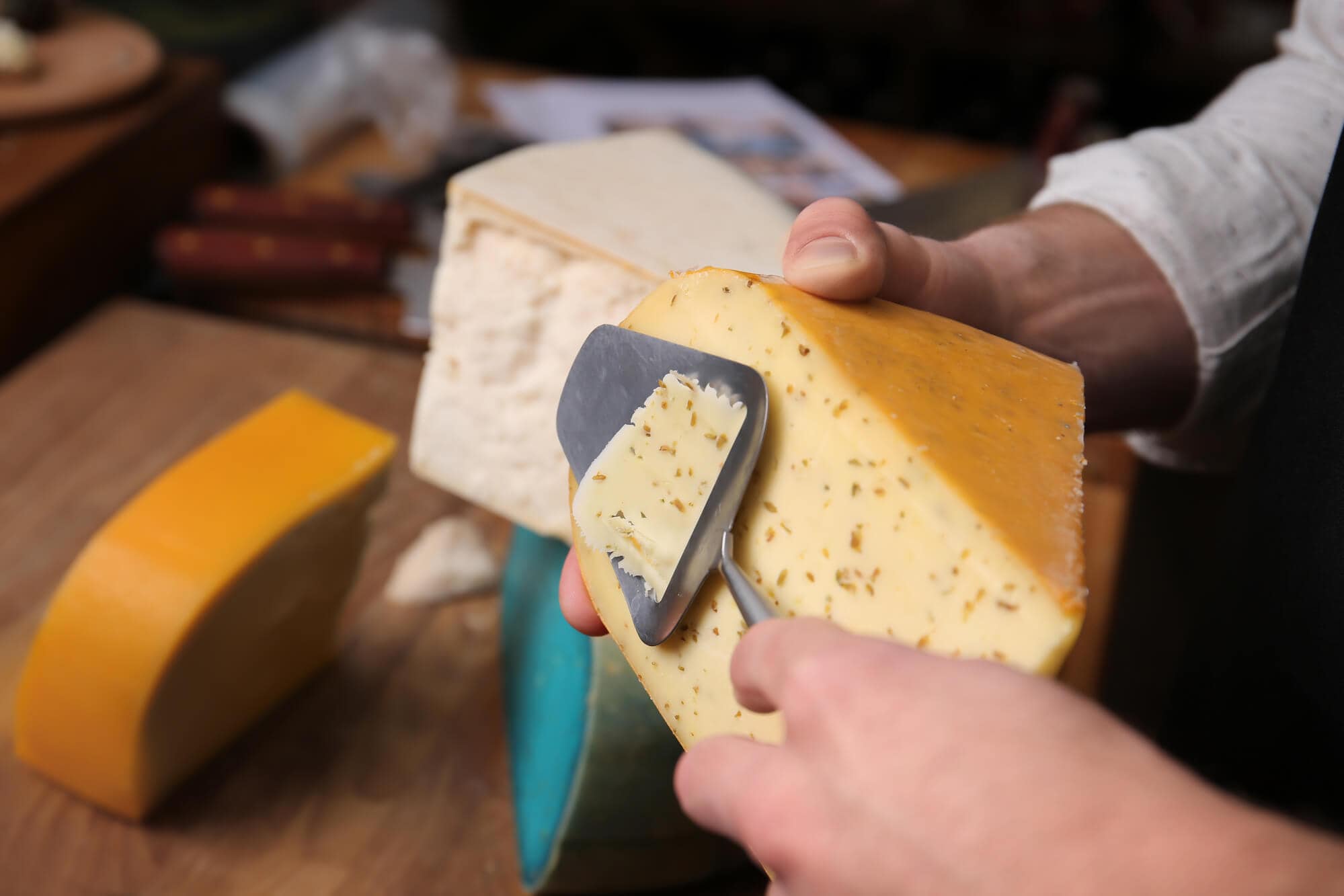 Fun fact about Norway, man slicing a piece of cheese with a cheese slicer, a Norwegian invention.