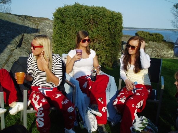 Three girls wearing red pants during a russefeiring in Norway.