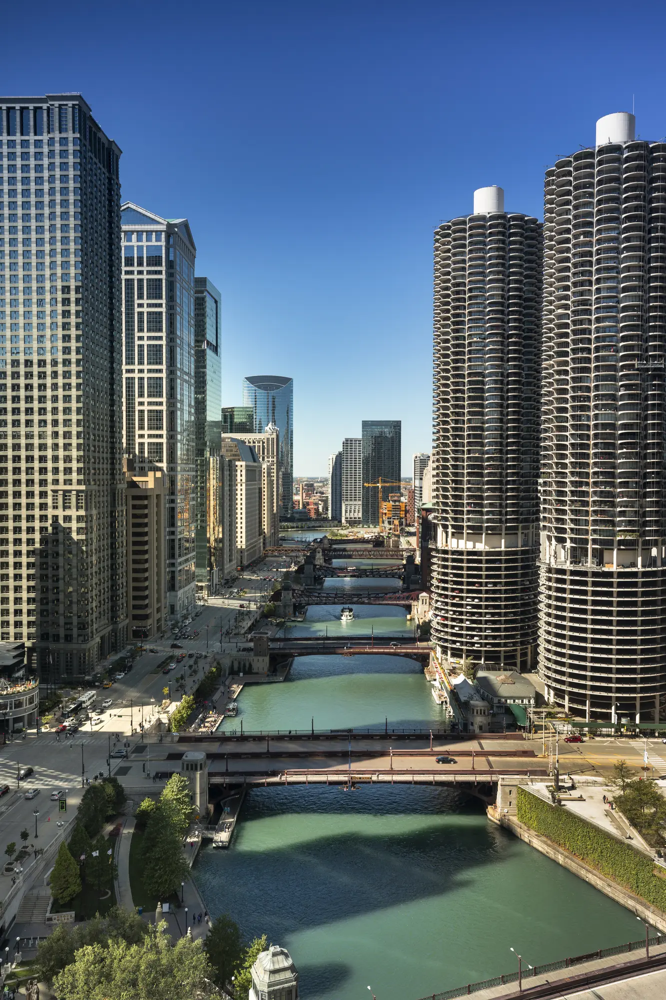 The green Chicago River running past sky scrapers and Marina City on a sunny day, during a architectural river cruise in Chicago.