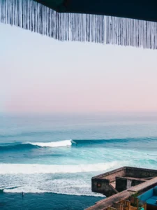 Looking out on a surfer on a wave from the Uluwatu cliff early in the morning, one of the best places to stay in Bali.