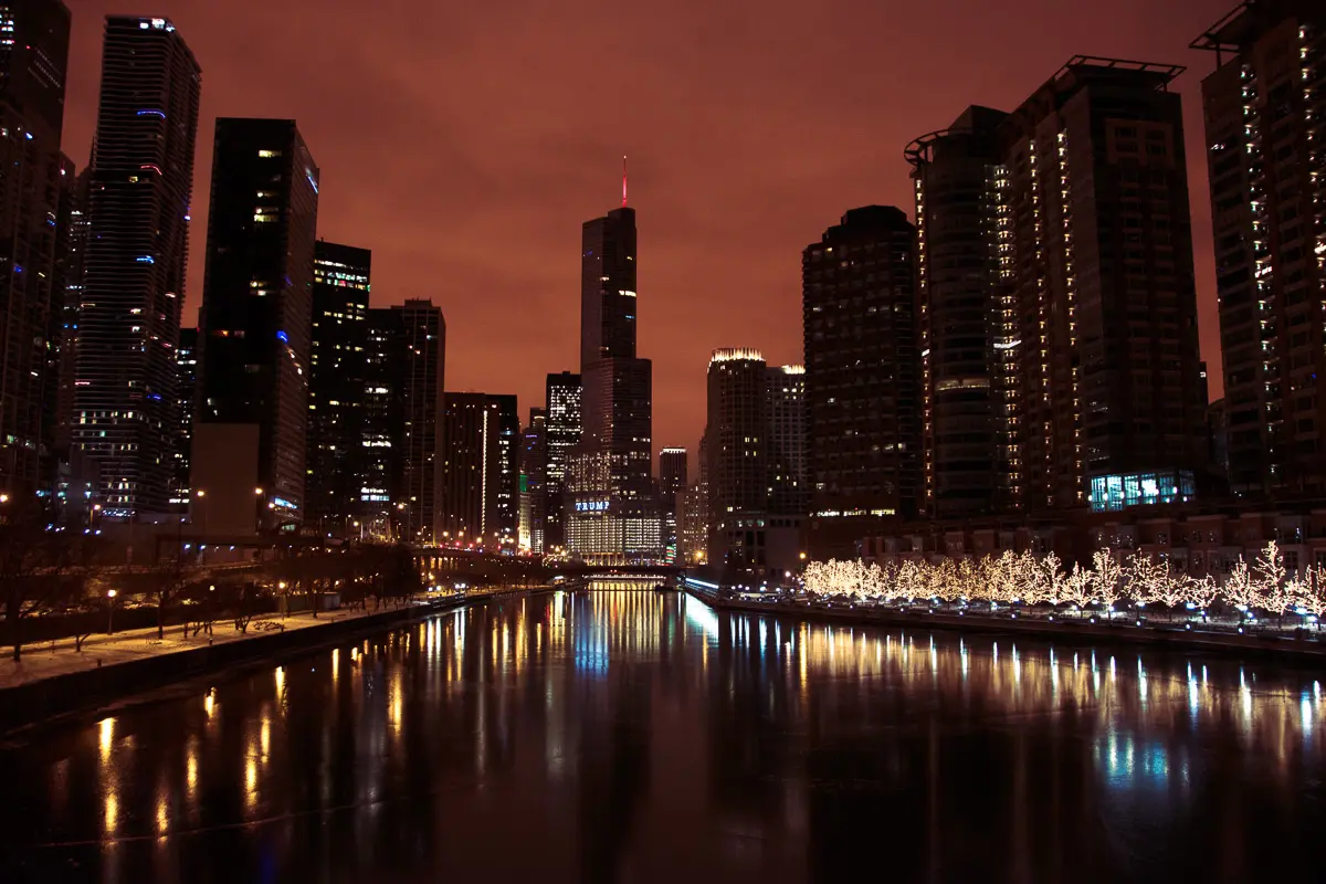 Chicago river and skyline by night set against a red sky, during a architecture river cruise of Chicago.