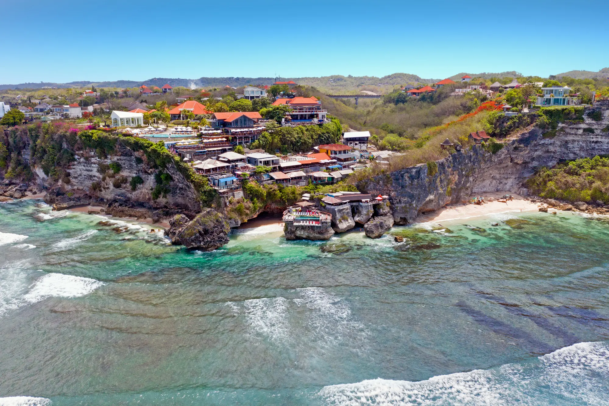 Drone view of two beaches and warungs on the cliff in Uluwatu.