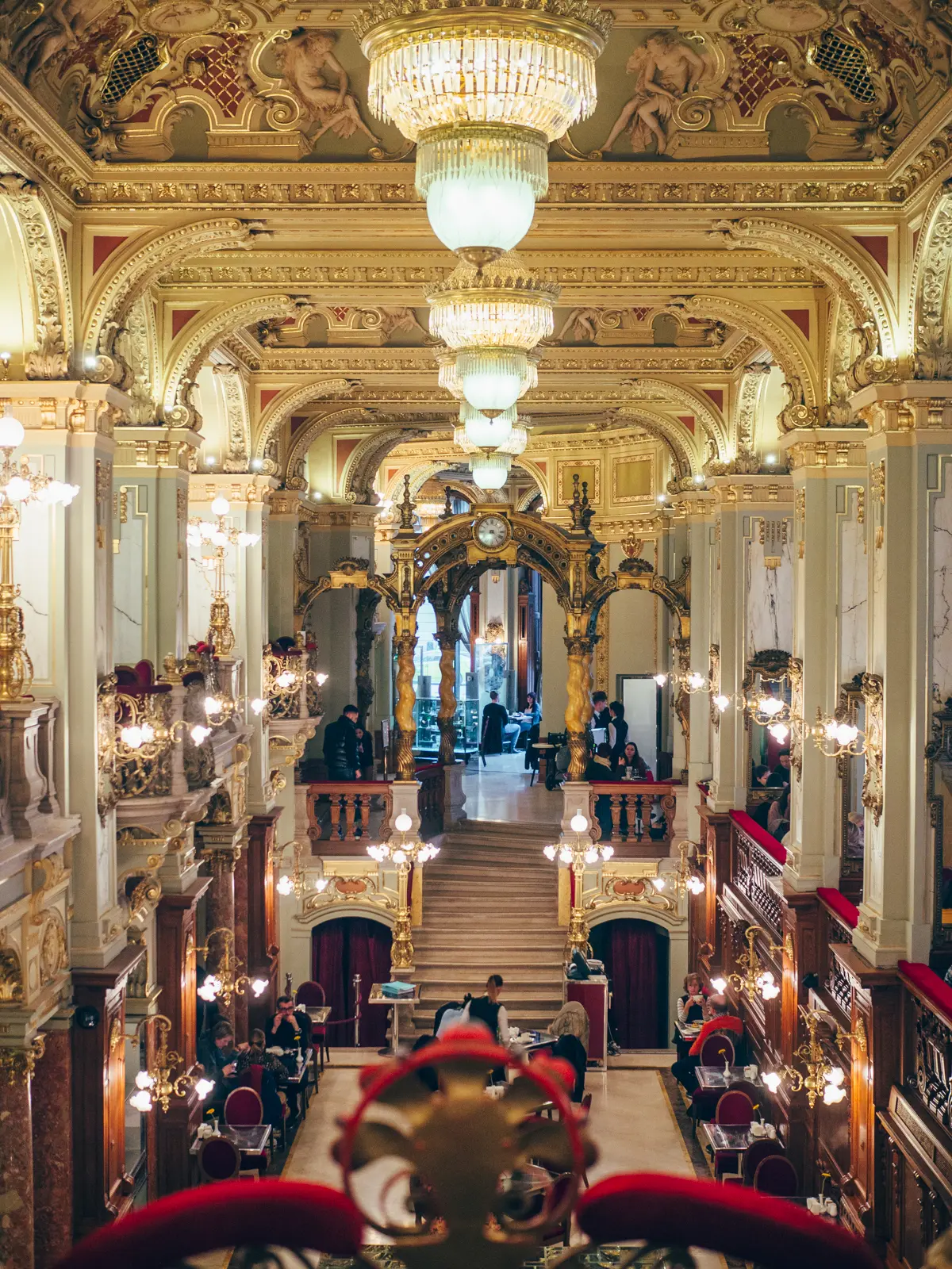 Inside the famous old world New York Caf&eacute; in Budapest, decorated with chandeliers, red velvet and gold leaf.