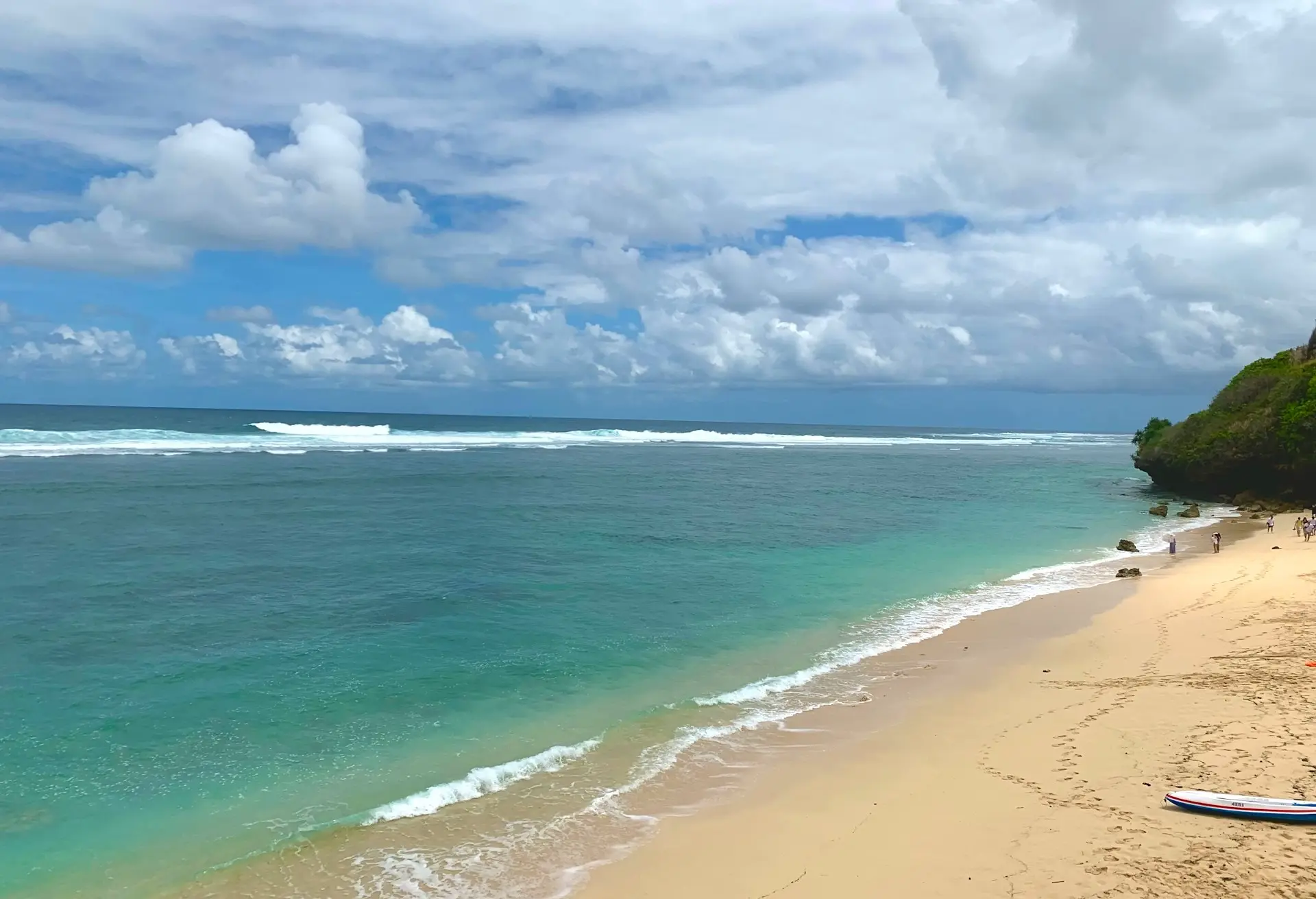 Golden sand and turquoise water on a cloudy day, Pantai Gunung Payung one of the best beaches in Uluwatu Bali.