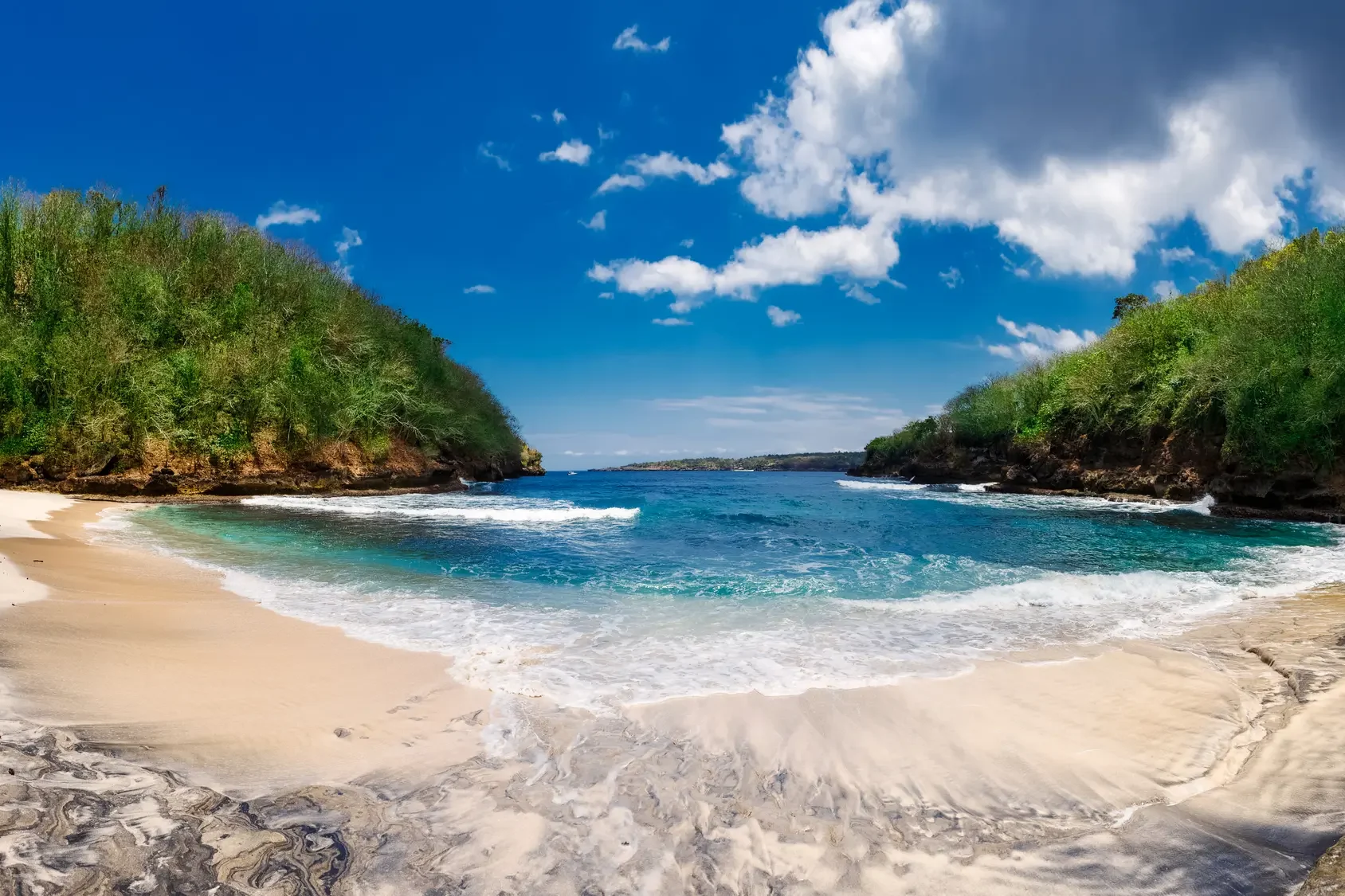 Pandan Beach, a small sandy cove, set between two lush headlands, next to Crystal Bay, one of the best places to visit in West Nusa Penida.