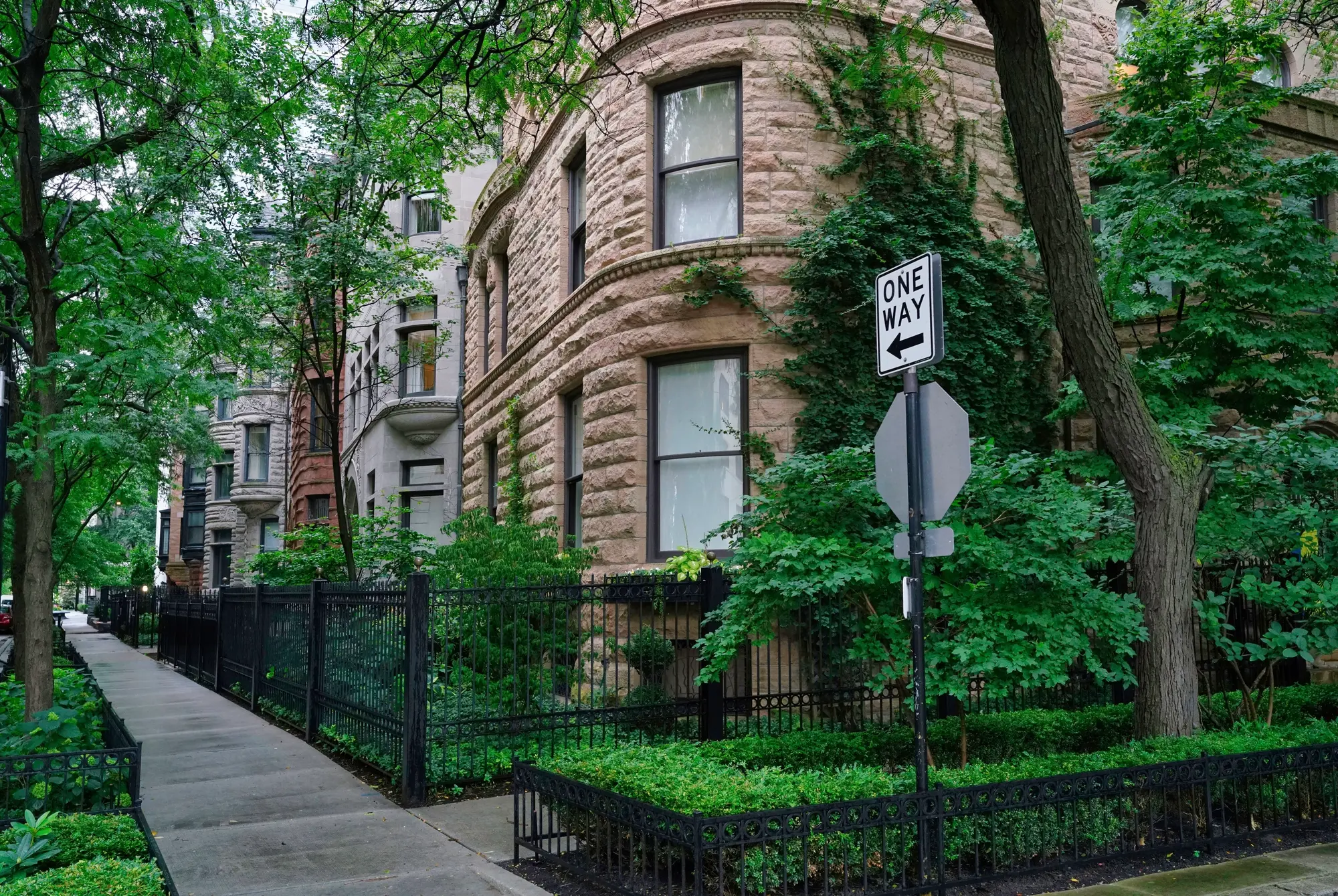 Row of stately homes along a tree lined street in Gold Coast, one of the best areas ti stay in Chicago for first-timers.