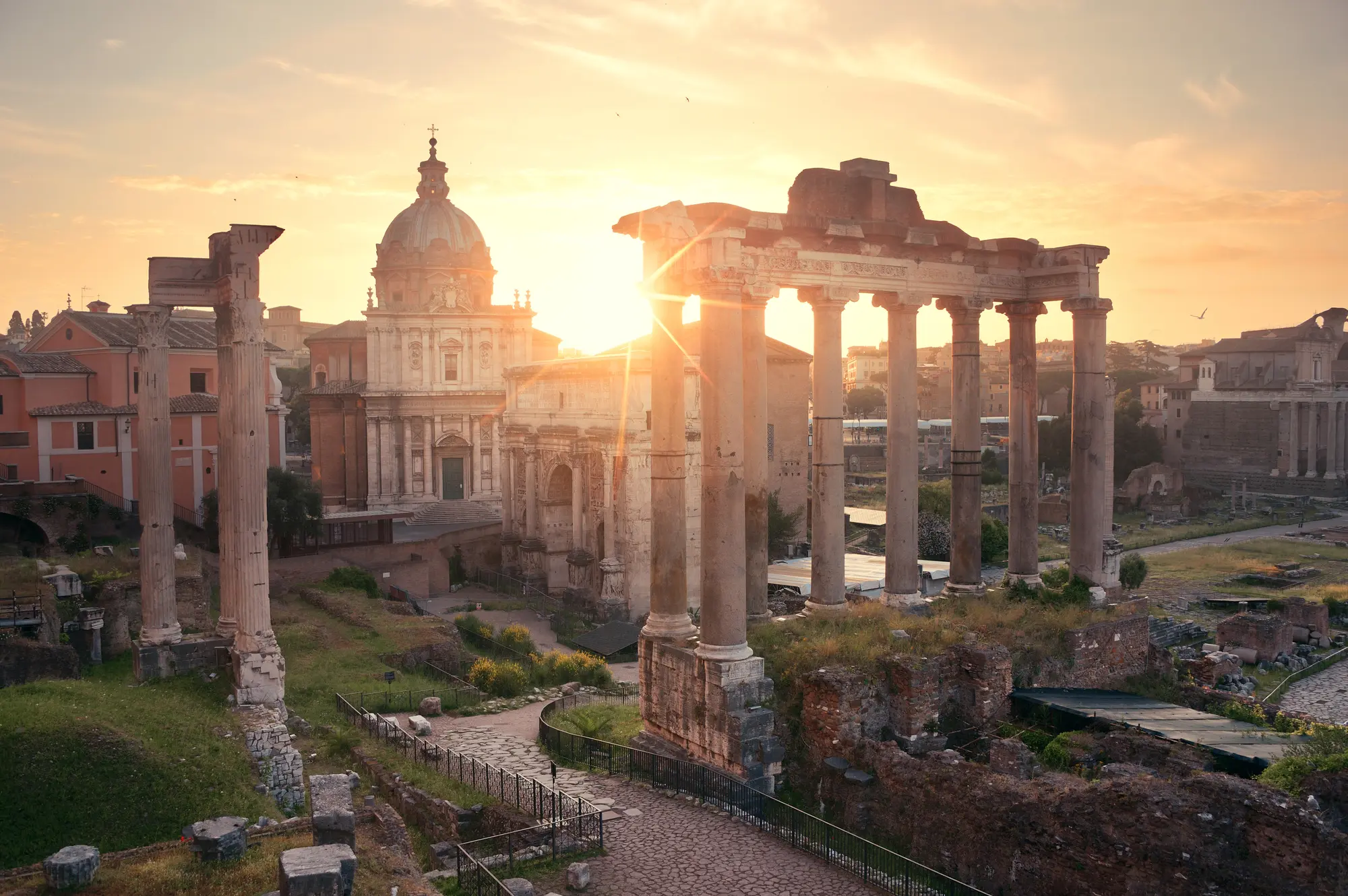 Yellow sunrise over an old church and ruins in Rome, Italy. Is Rome safe?
