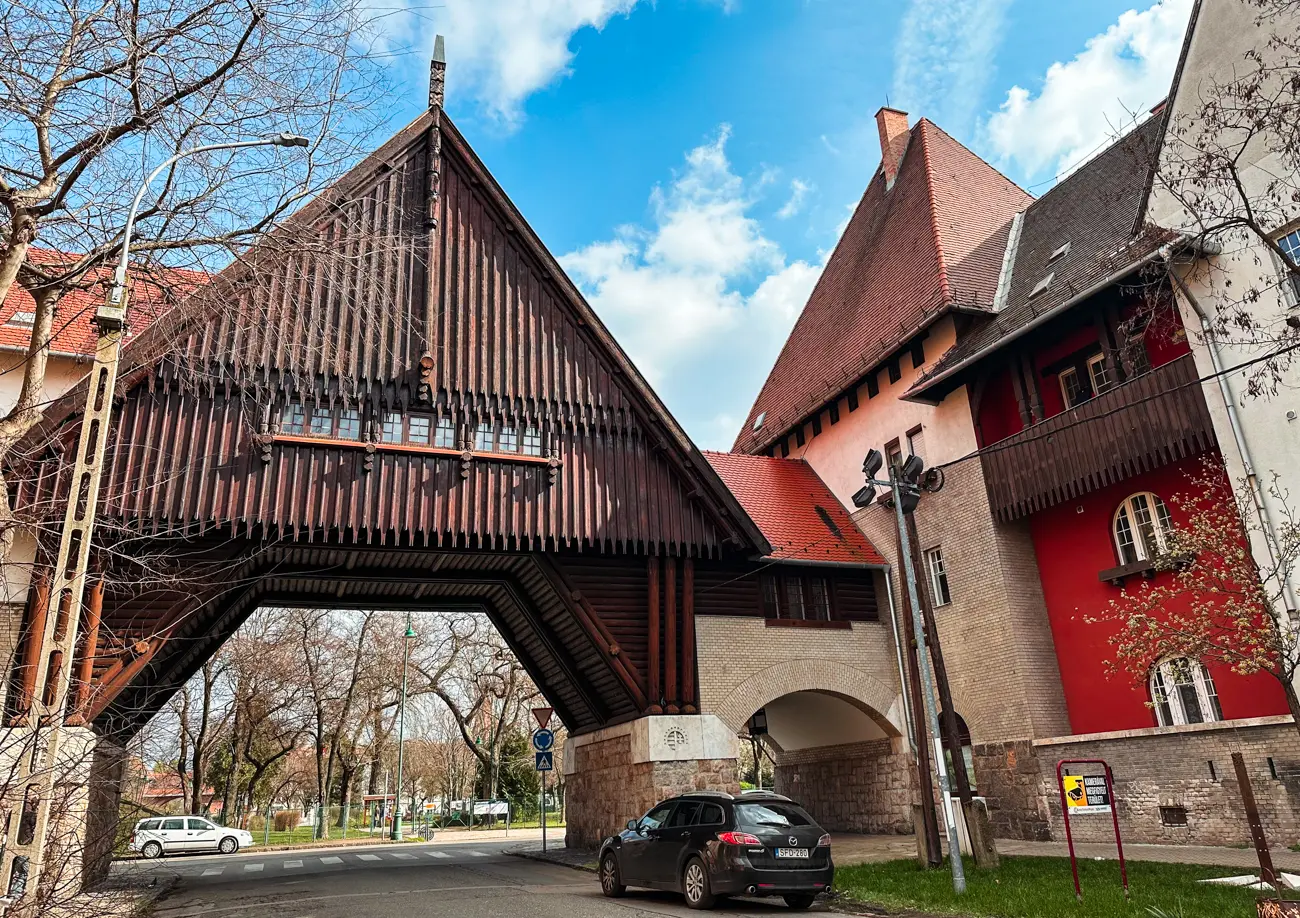 Large Medieval looking wooden gate and brick houses of Wekerletelep (Wekerle Estate), a hidden gem in Budapest.