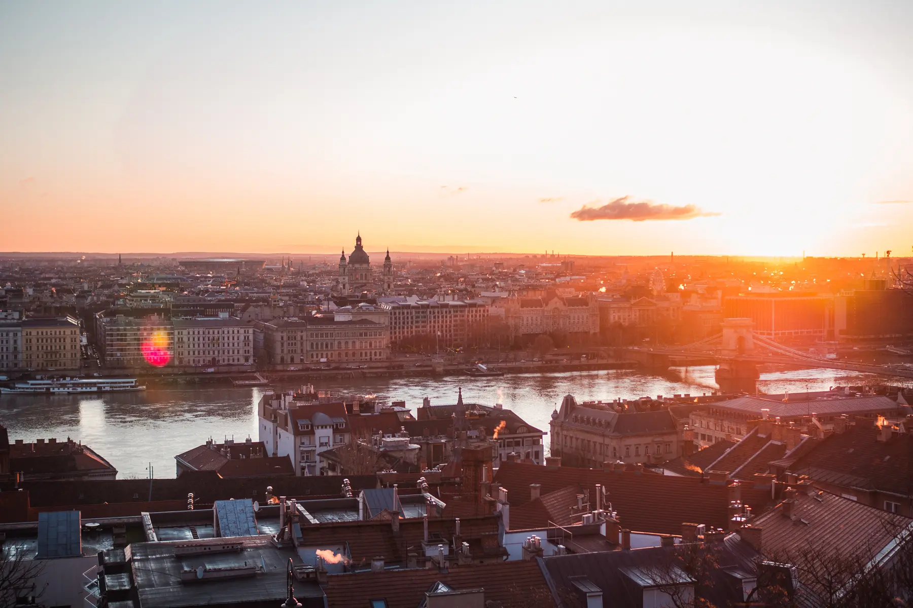 View over Pest, Danube River and hidden gems from Buda Castle during an orange sunrise in Budapest.