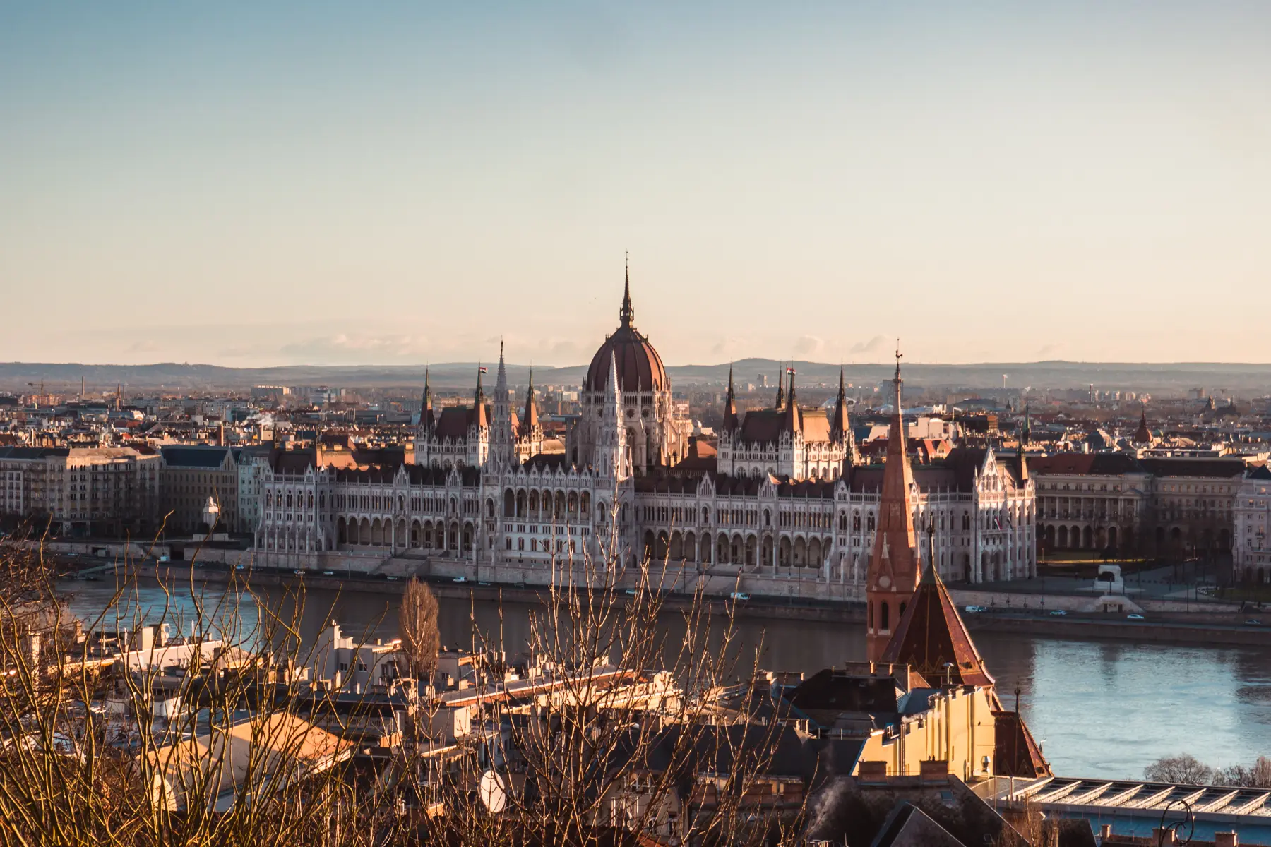 View of the majestic Budapest Parliament from across the Danube River at sunrise.