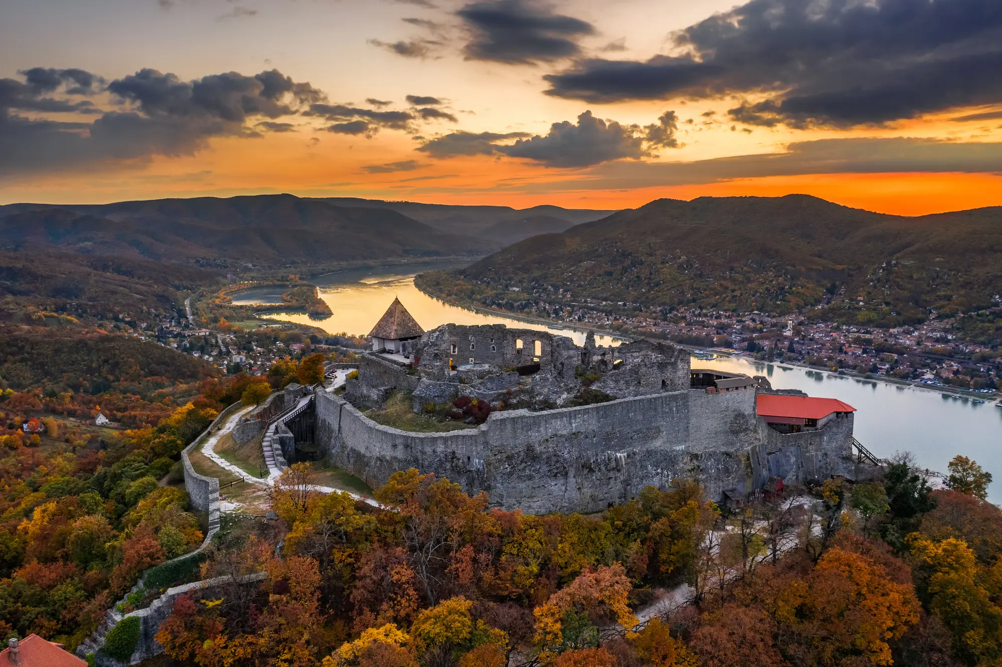 Grey stone fortress ruins on top of a hill overlooking Visegrad and the Danebu Bend at sunset, a hidden gem close to Budapest.