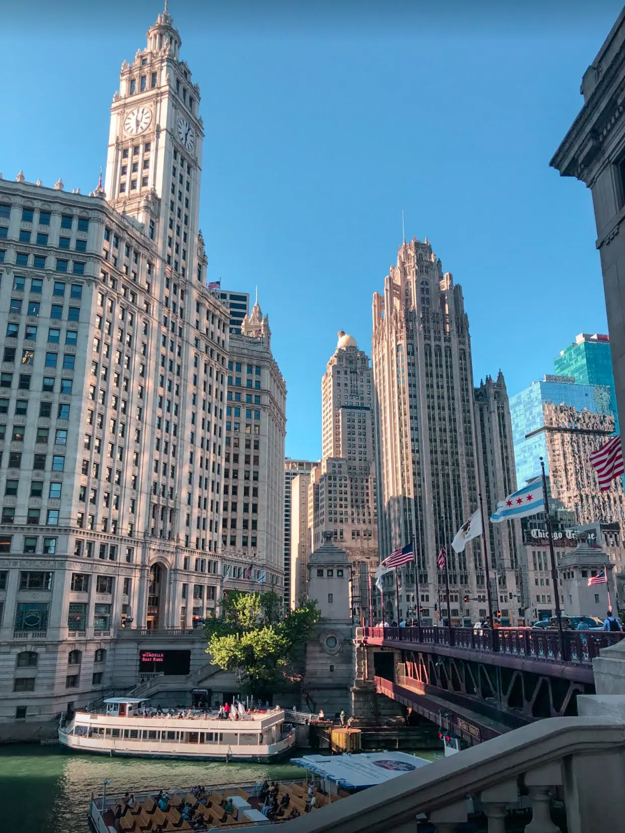 Riverwalk looking out over the mighty Wrigley building, a boat and the burgundy DuSable Bridge, a must during your weekend in Chicago.