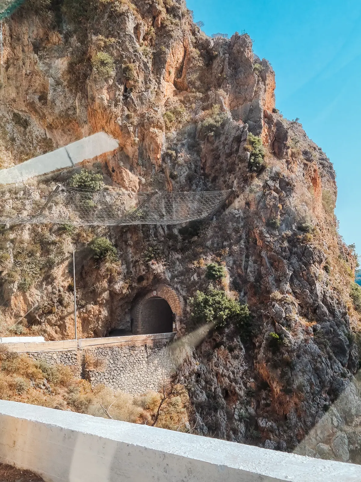 Looking towards a narrow tunnel going through the mountain on the coastal road from Chania and Falasarna to Elafonisi Beach in Crete.