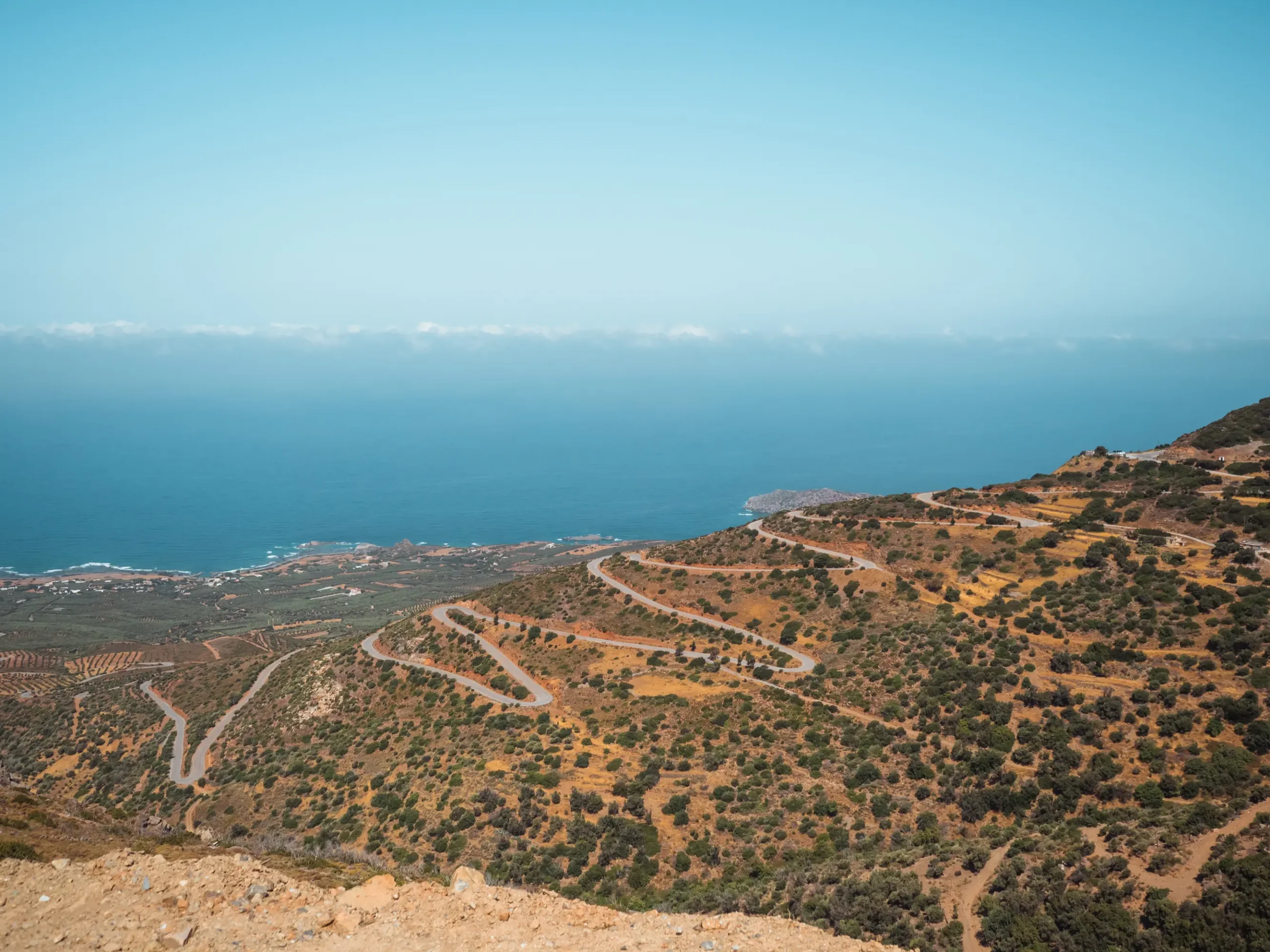 View from above of a windy mountain road with the sea in the background on the way from Chania and Falasarna to Elafonisi Beach.
