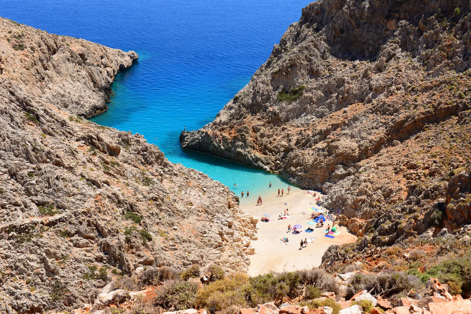 Seitan Limani Beach close to Chania, narrow patch of white sand and turquoise water running between to steep hillsides.