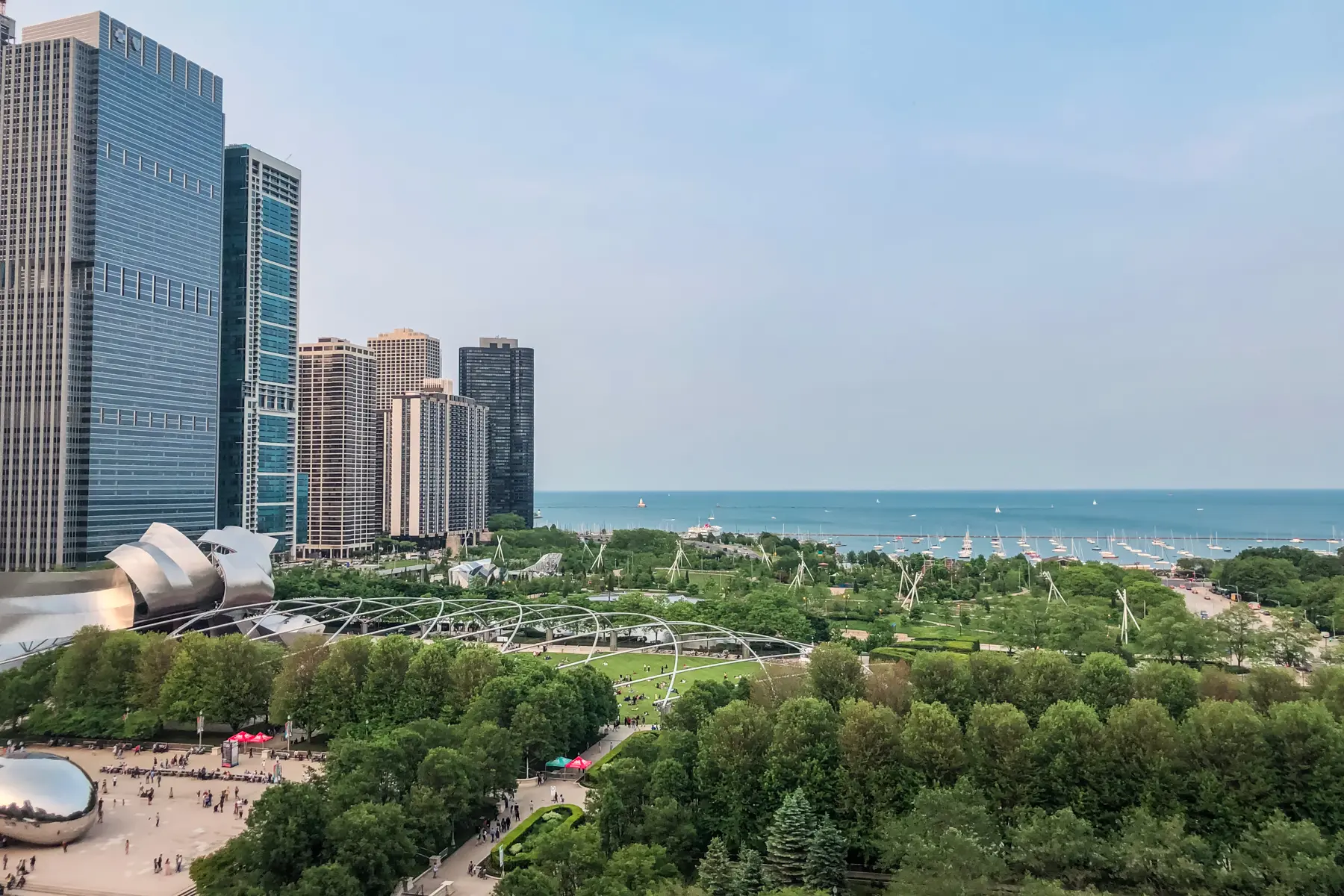 View of Lake Michigan and the lush green Millenium Park with the Bean and skyscrapers to the left from Cindy's Rooftop, one of the top things to do in Chicago on a weekend.